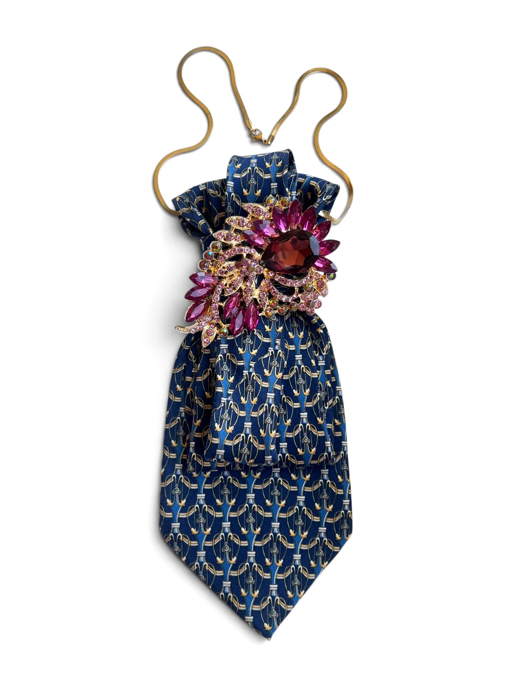 Blaue Krawatte mit Muster mit dekorativer Brosche auf weißem Hintergrund fotografiert