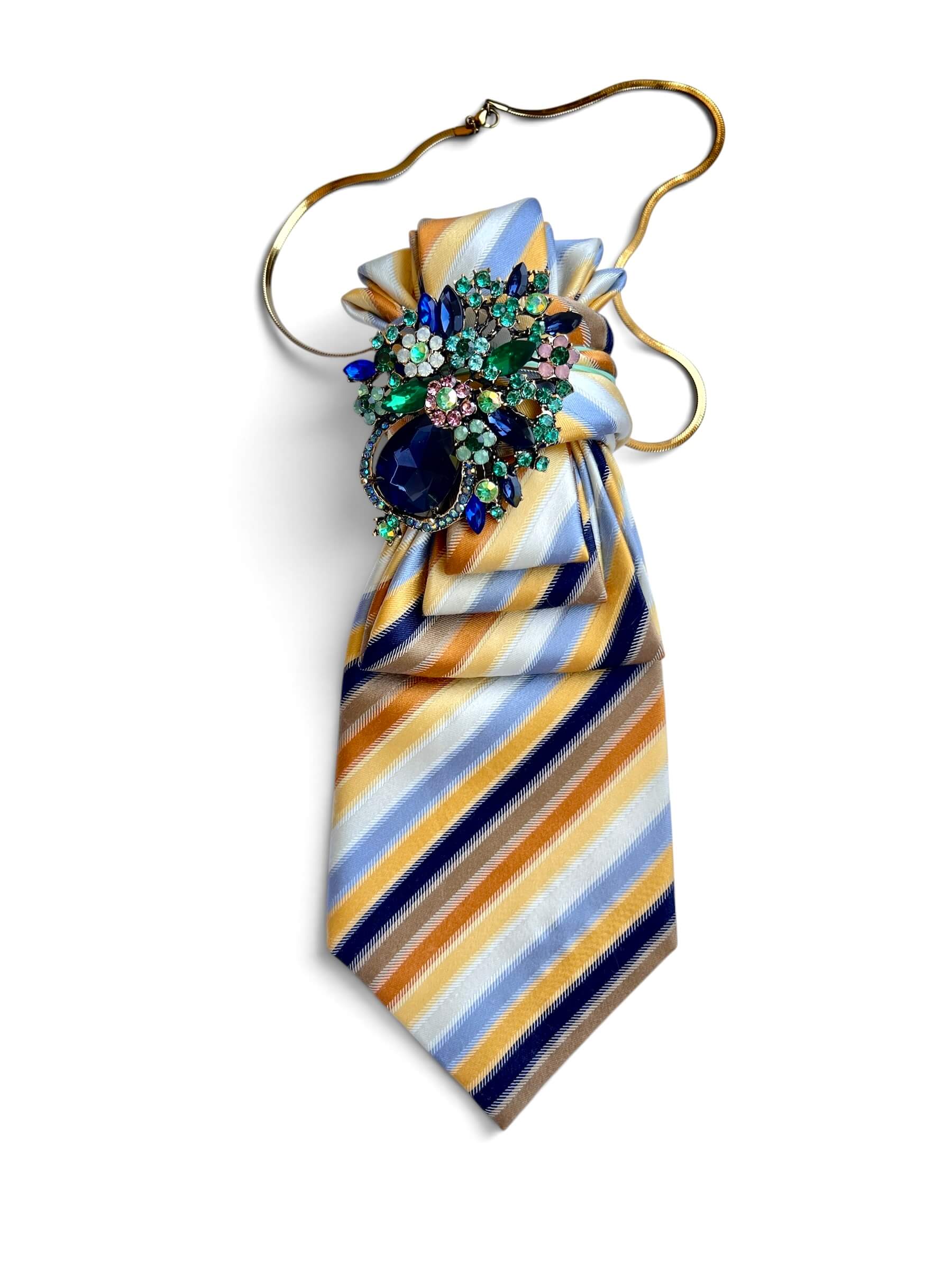 Gestreifte Krawatte in verschiedenen bunten Farben mit dekorativer Brosche auf weißem Hintergrund fotografiert