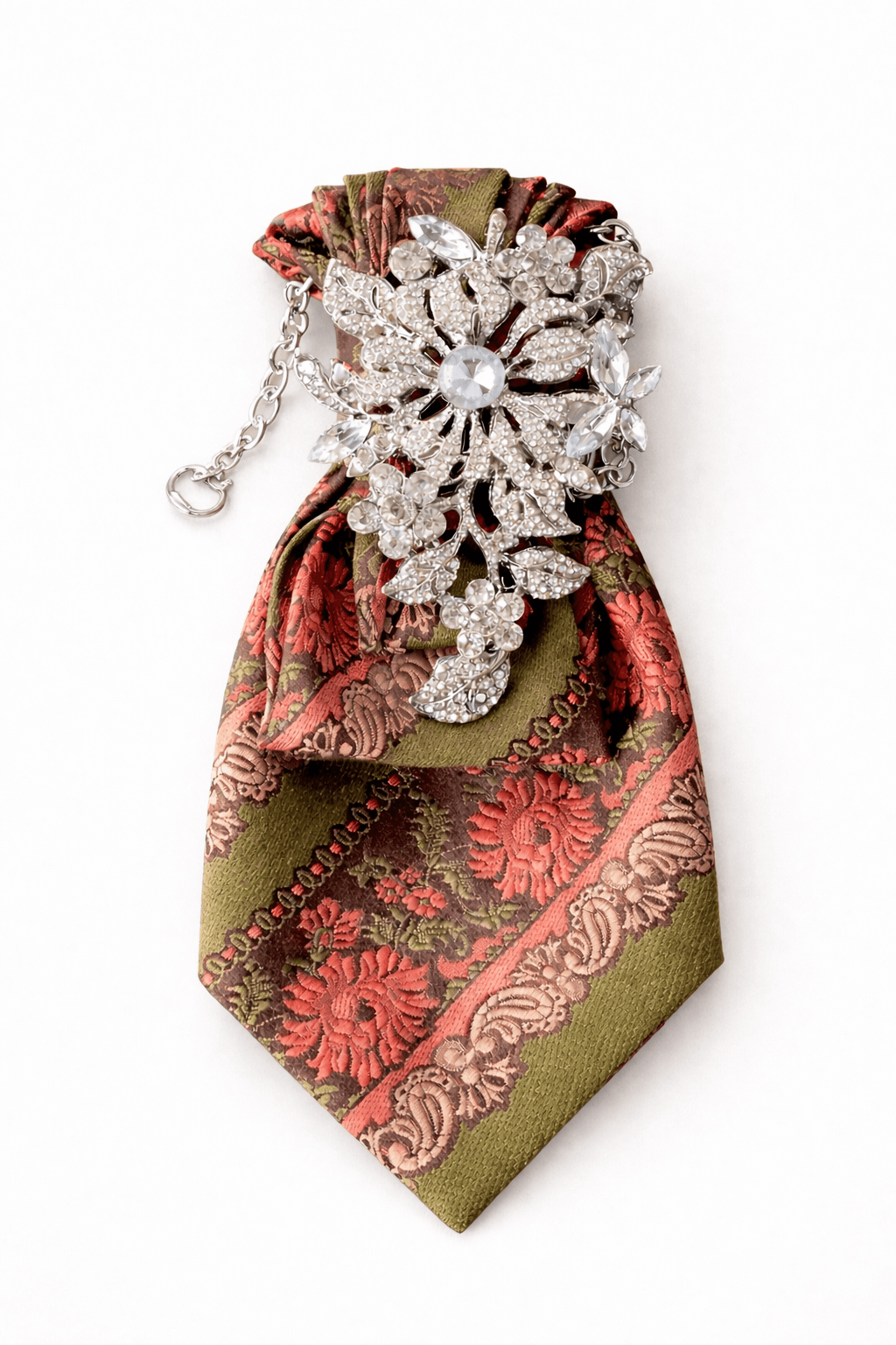 Lila Krawatte mit kariertem Muster in verschiedenen Violetttönen, dekorativ gebunden und mit einer großen, mehrfarbigen Brosche mit violetten und roséfarbenen Steinen verziert, freigestellt vor hellem Hintergrund.