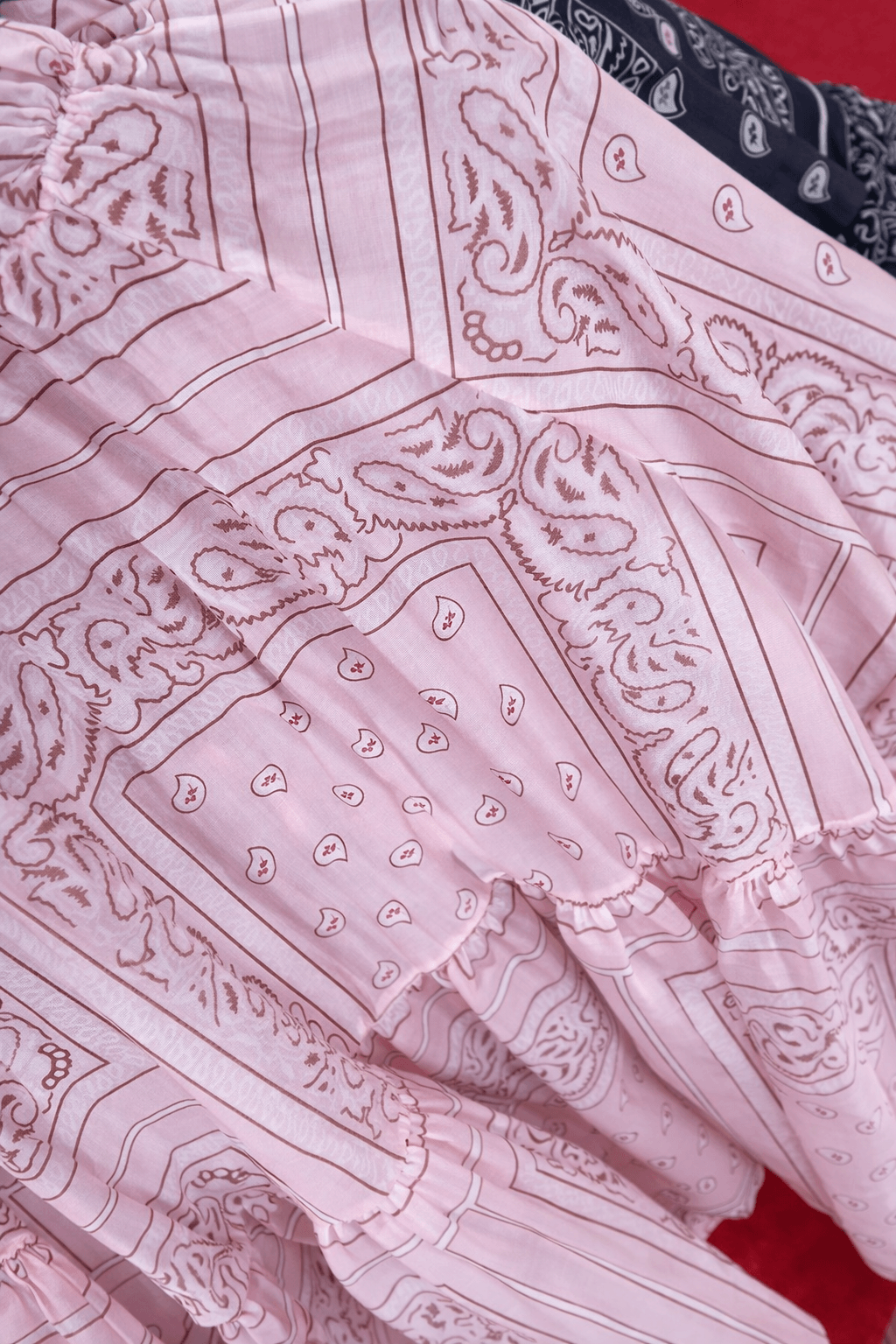 Leicht fallender Stoff mit Paisley-Muster in Rosa mit feinen Linien und gerafftem Bund.