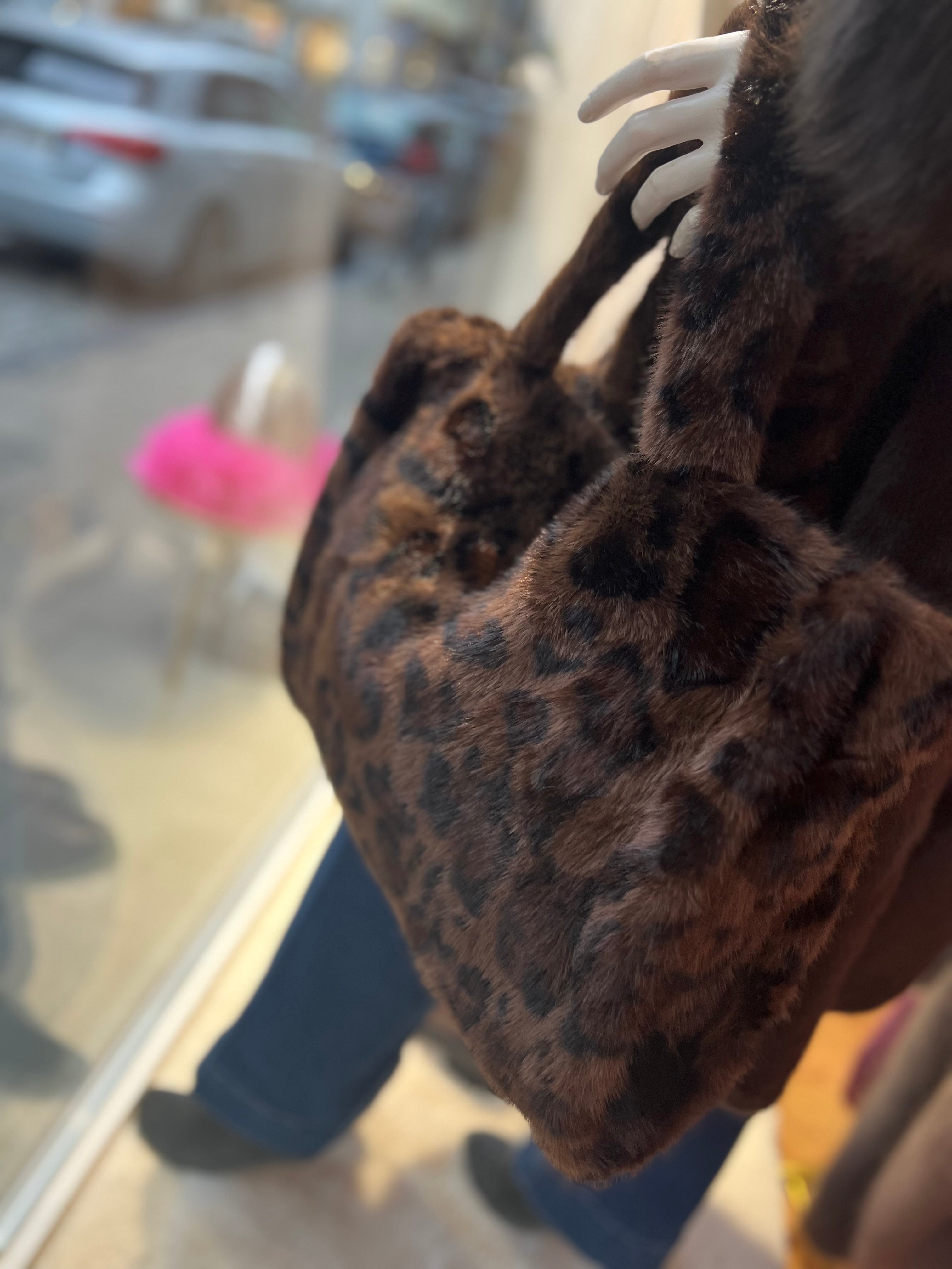 Schaufensterpuppe trägt Leo Tasche in Braun. An Fenster dekoriert.