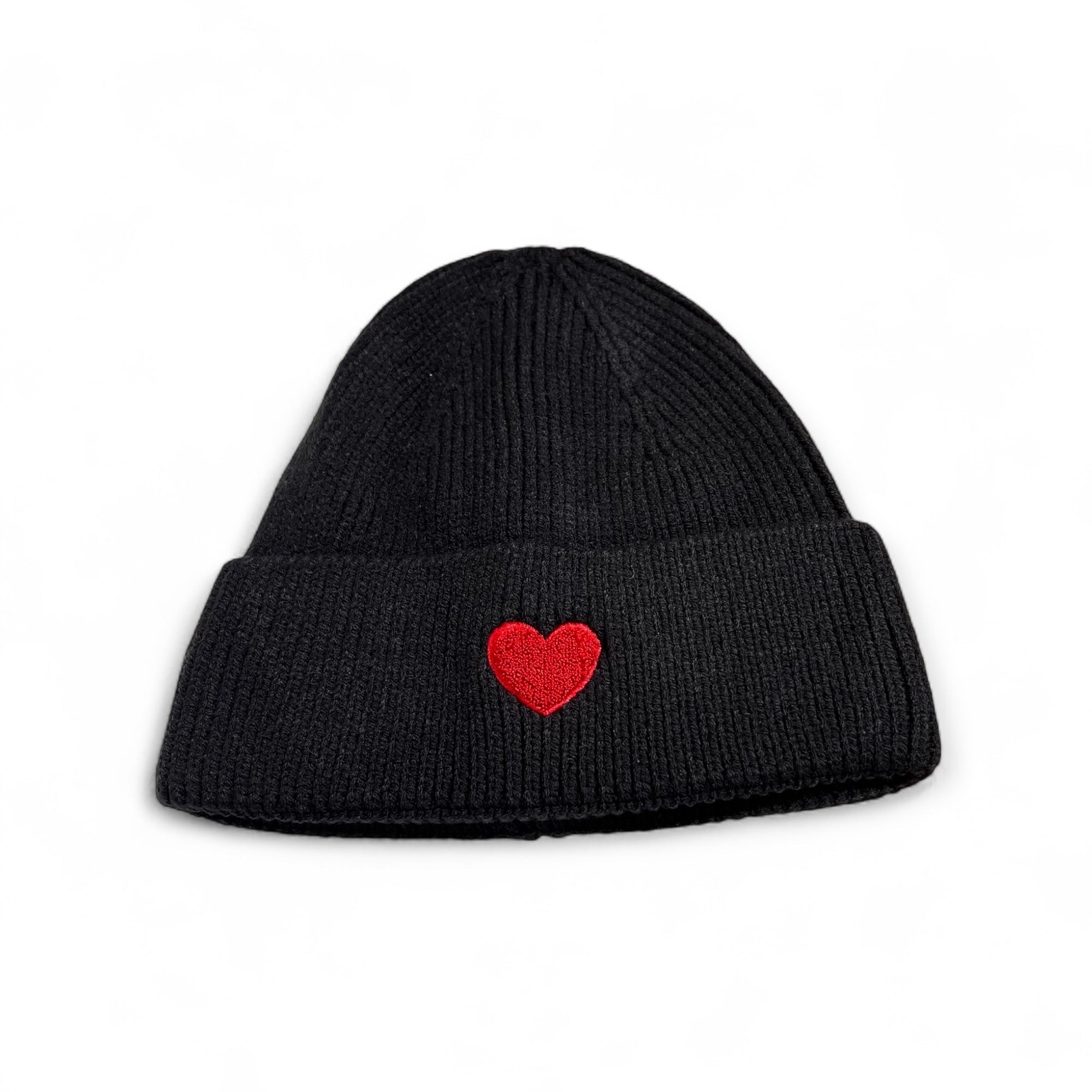 Schwarze Strickmütze aus Viskose mit aufgesticktem rotem Herz auf der Vorderseite, fotografiert auf weißem Hintergrund.