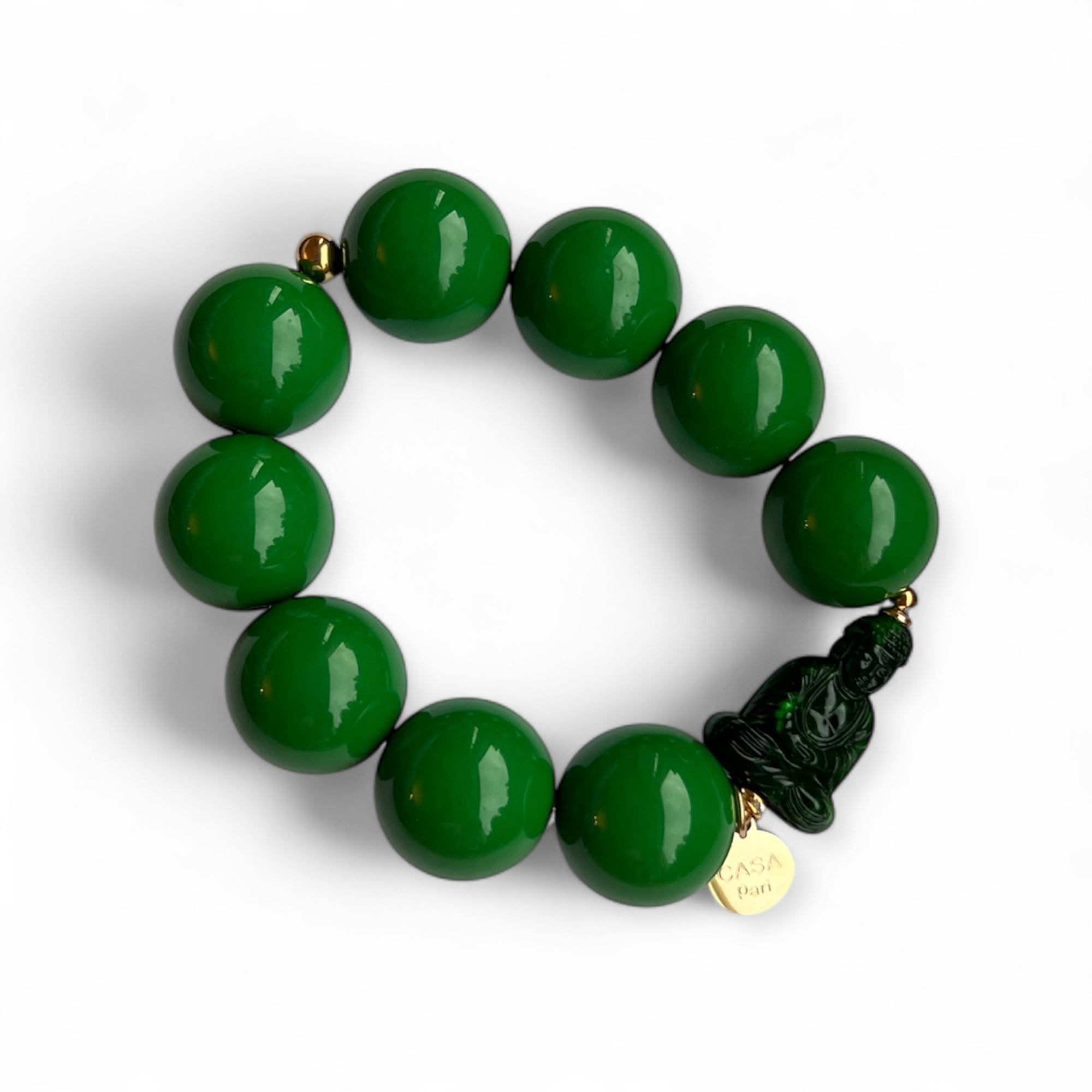 Grünes Armband aus glänzenden Kunstharzperlen mit einem kleinen Buddha Element. Handgefertigt von Casapari auf weißem Hintergrund.