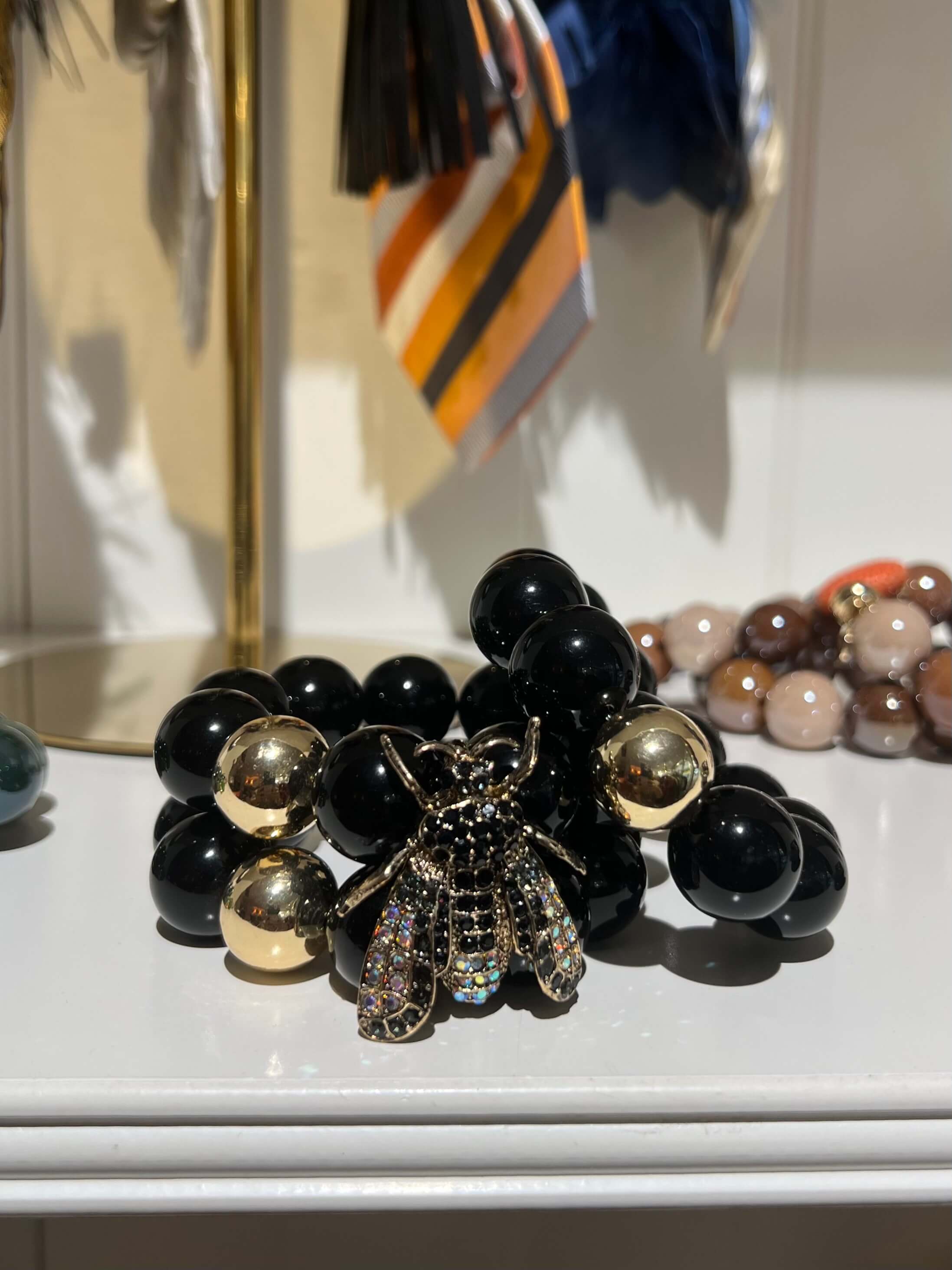 Zwei gemachtes Arbeit mit einer goldenen Perle und goldene Biene vorne in einer Boutique fotografiert