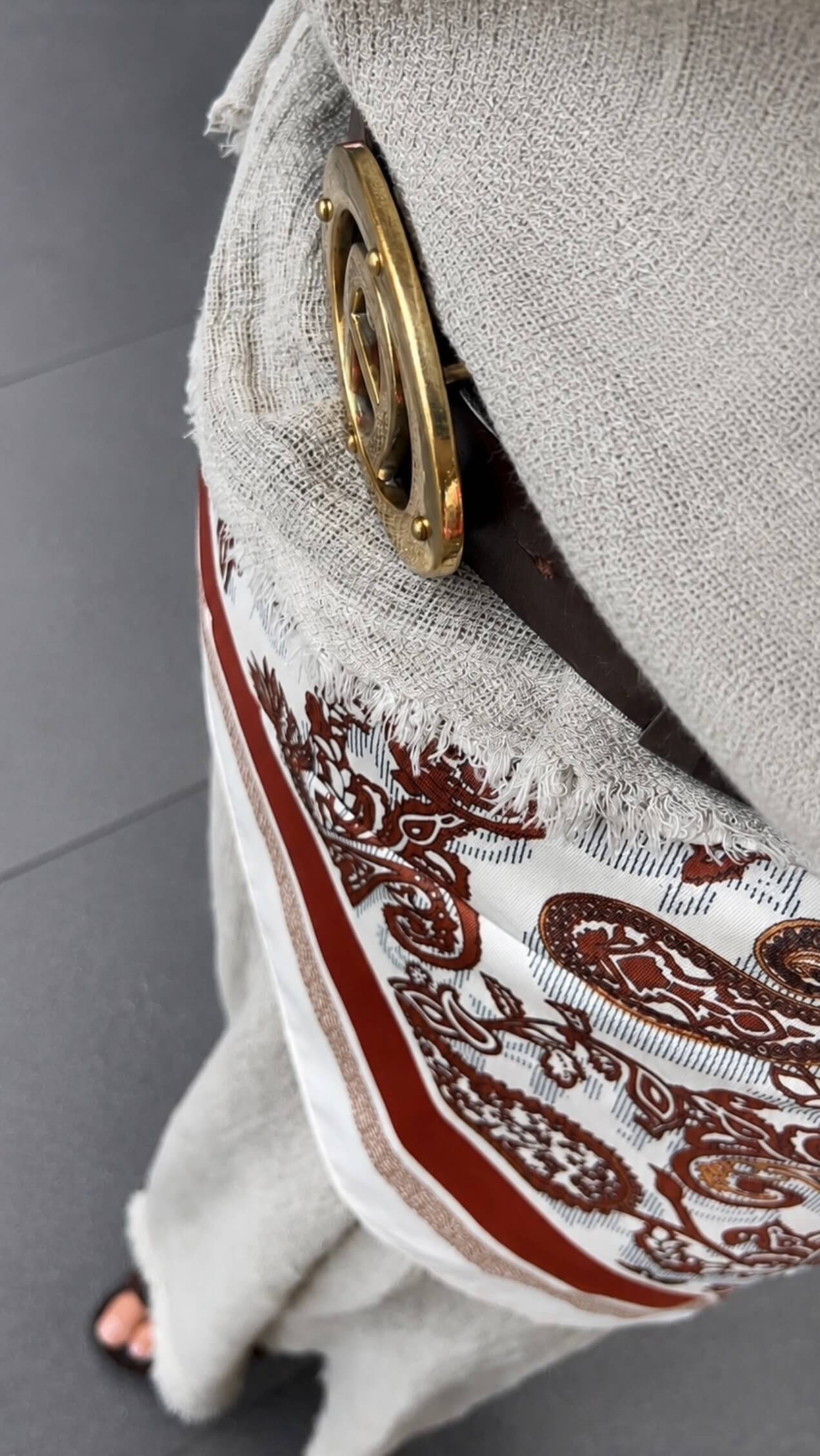 Eine Frau steht auf der Straße sie trägt einen Rock mit einem Paisley Tuch