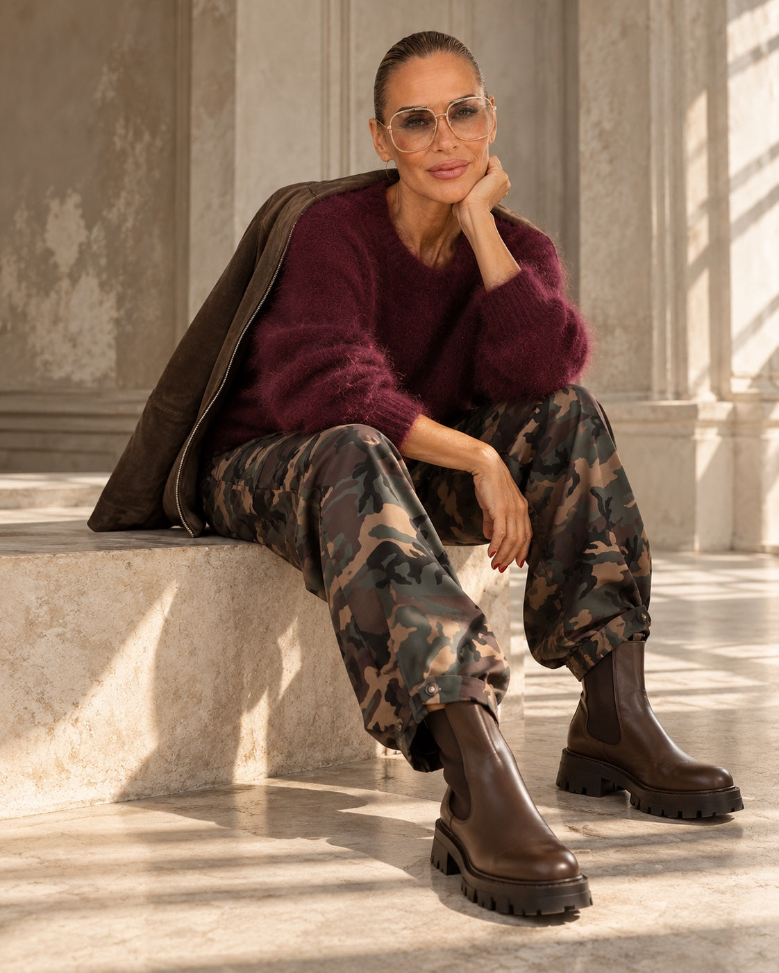 Model in Camouflage Barrel Pants mit burgunderfarbenem Mohairpullover und braunen Chelsea Boots