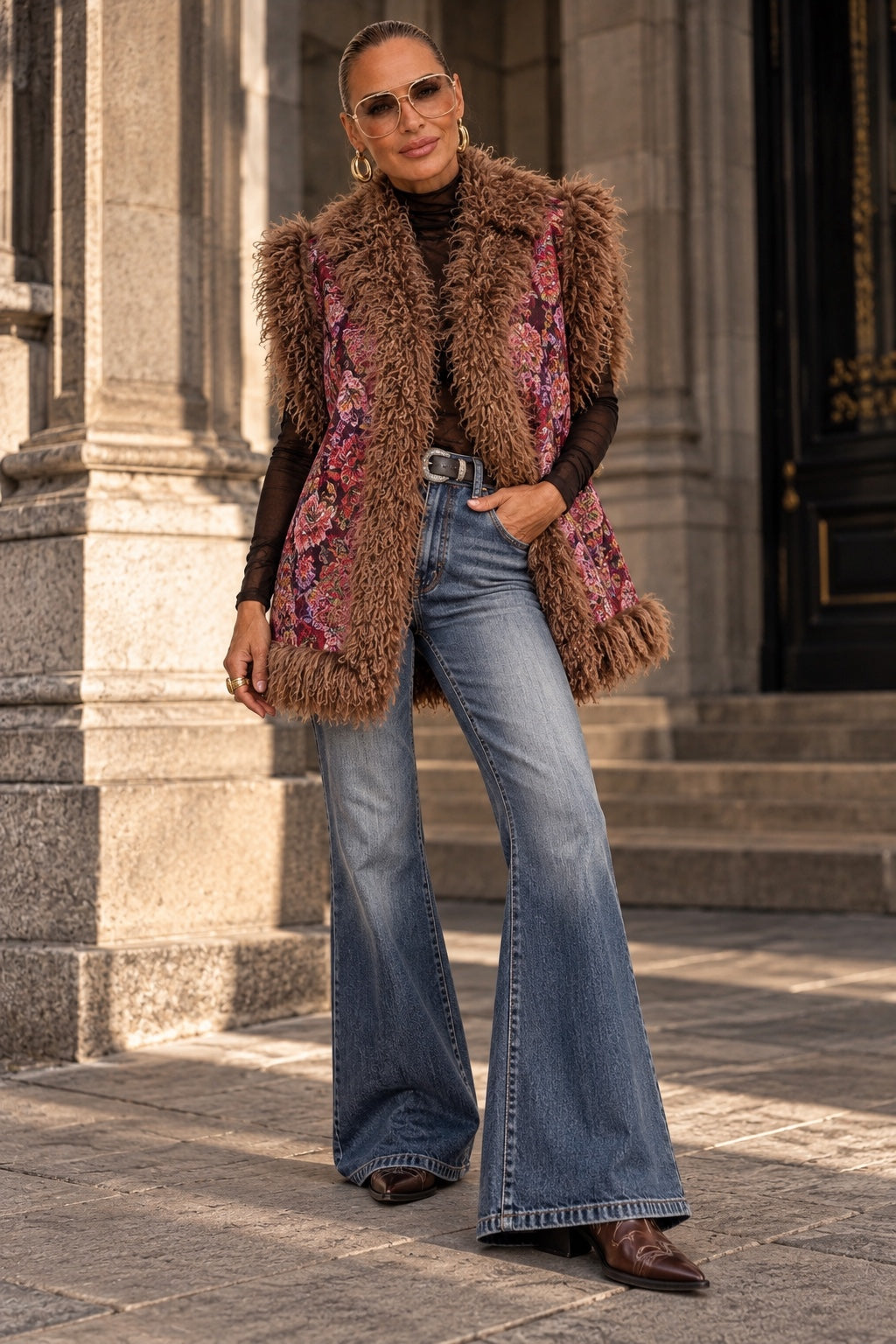 Model trägt The Boho Icon Statement Weste mit ausgestellter Jeans