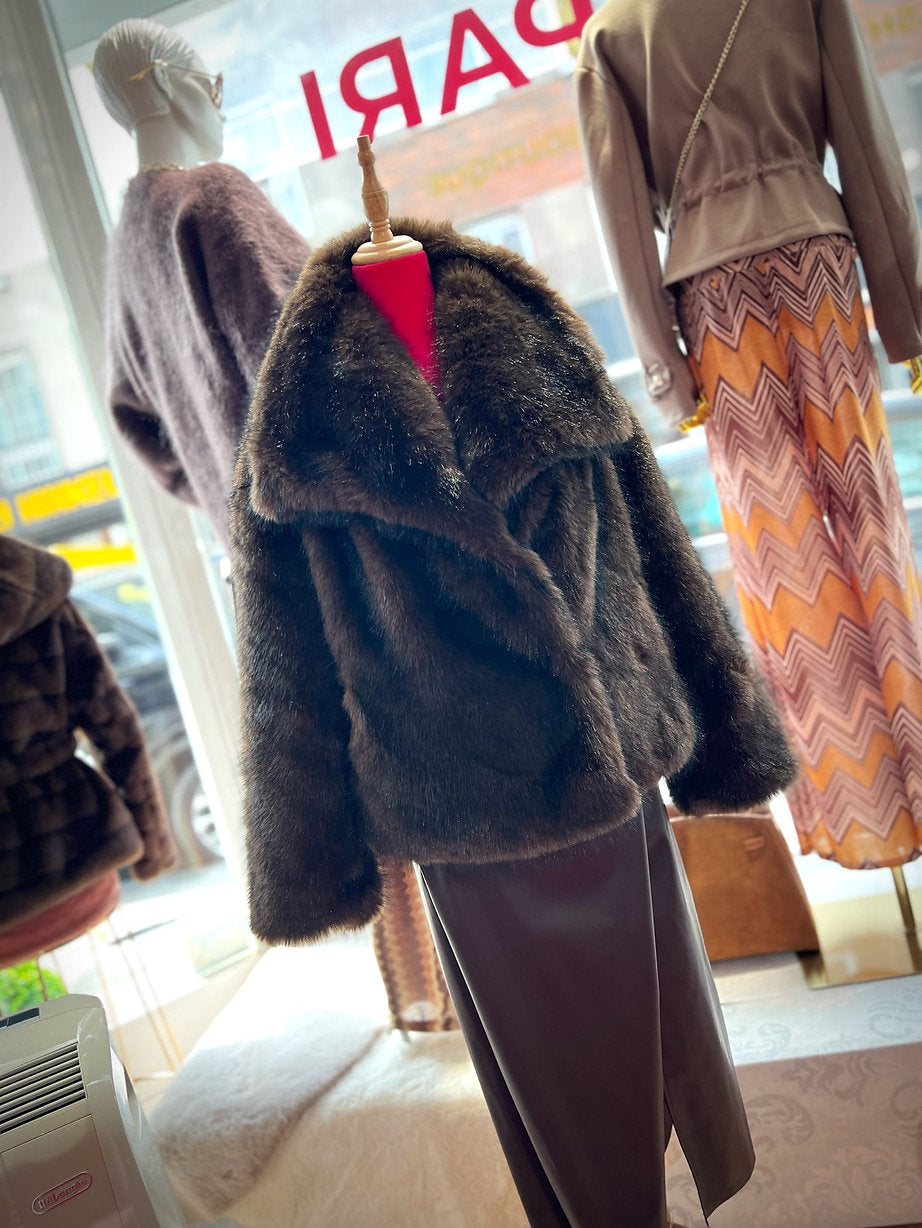 Fake Fur Jacke in Braun auf Schneiderpuppe mit Rock kombiniert. hinunter Schaufenster mit Puppen mit stylischer Mode.