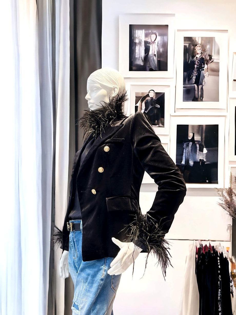 Seitliche Ansicht des CASAPARI® Samtblazers in Schwarz. Taillierter Schnitt, edler Samt mit weichem Fall, goldfarbene Knöpfe sichtbar.