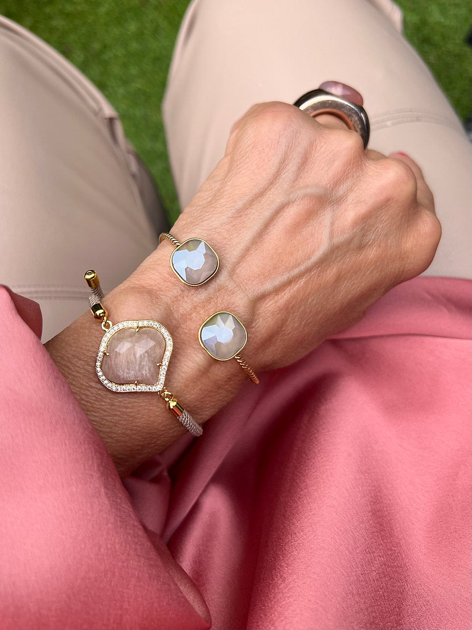 Nahaufnahme eines handgefertigten Armband Set mit Cat Eye Steine in Caffè Latte und Taupe. Getragen am Handgelenk, schlichte Farben, goldenen Details, eleganter Look.