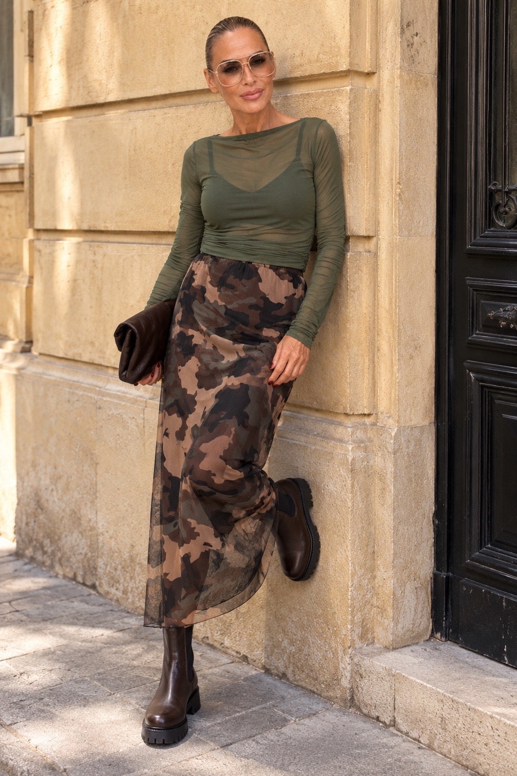 KI-generiertes Modelbild mit Camouflage Mesh Rock, olivgrünem Oberteil und braunen Boots
