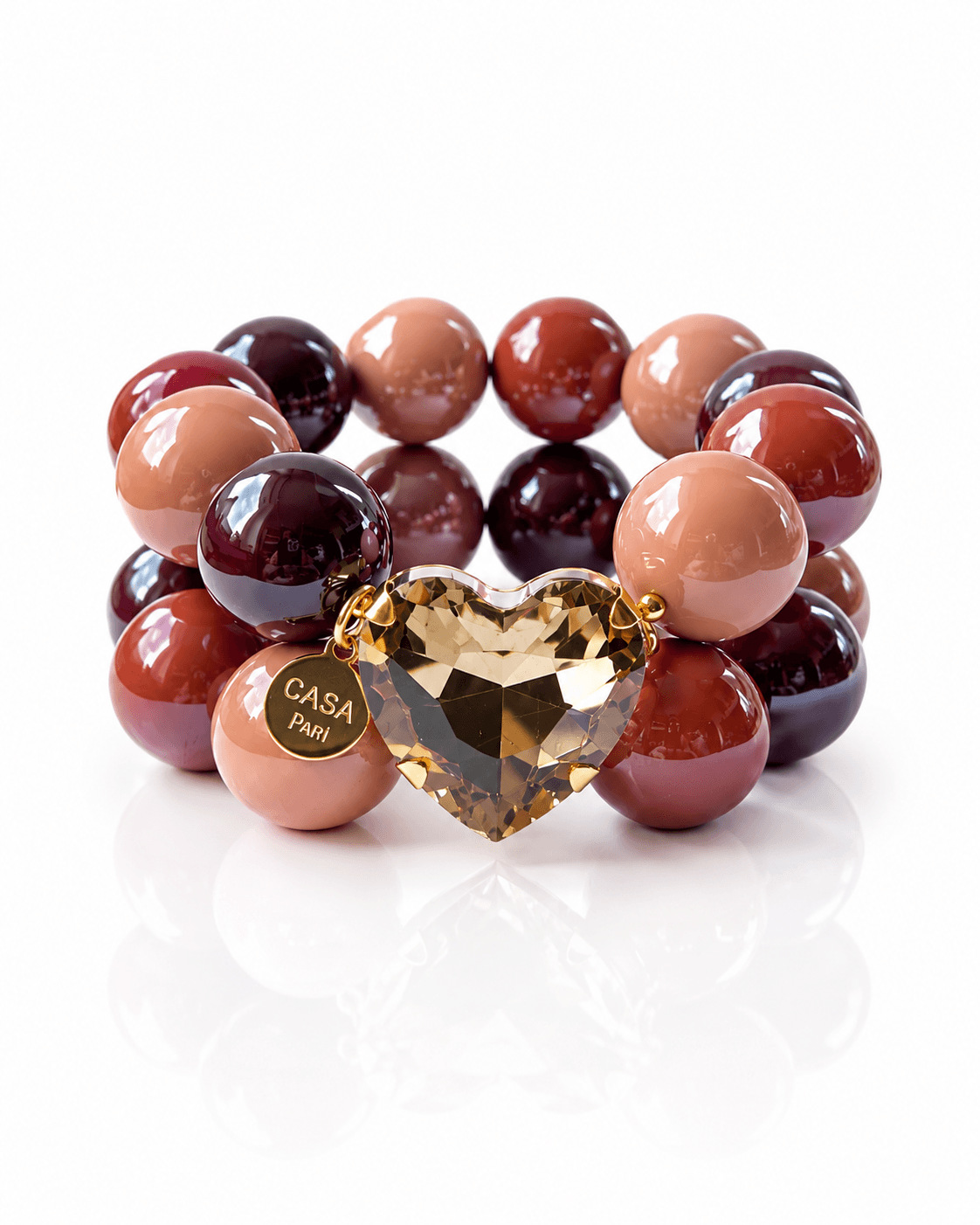 Doppelreihiges Crystal Hearts Armband von CASA Pari mit glänzenden Resin-Perlen in warmen Rosé-, Zimt- und Beerentönen sowie großem champagnerfarbenem Kristallherz und goldenem Logo-Anhänger.