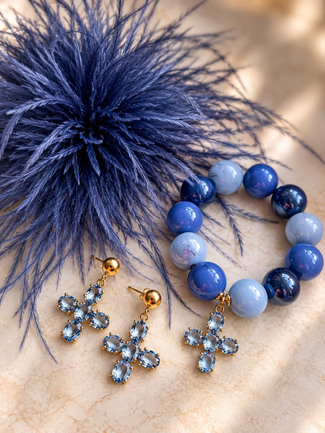Königsblaues Schmuckset mit Federbrosche, blauem Perlenarmband mit Kristallkreuz und passenden Kreuzohrringen