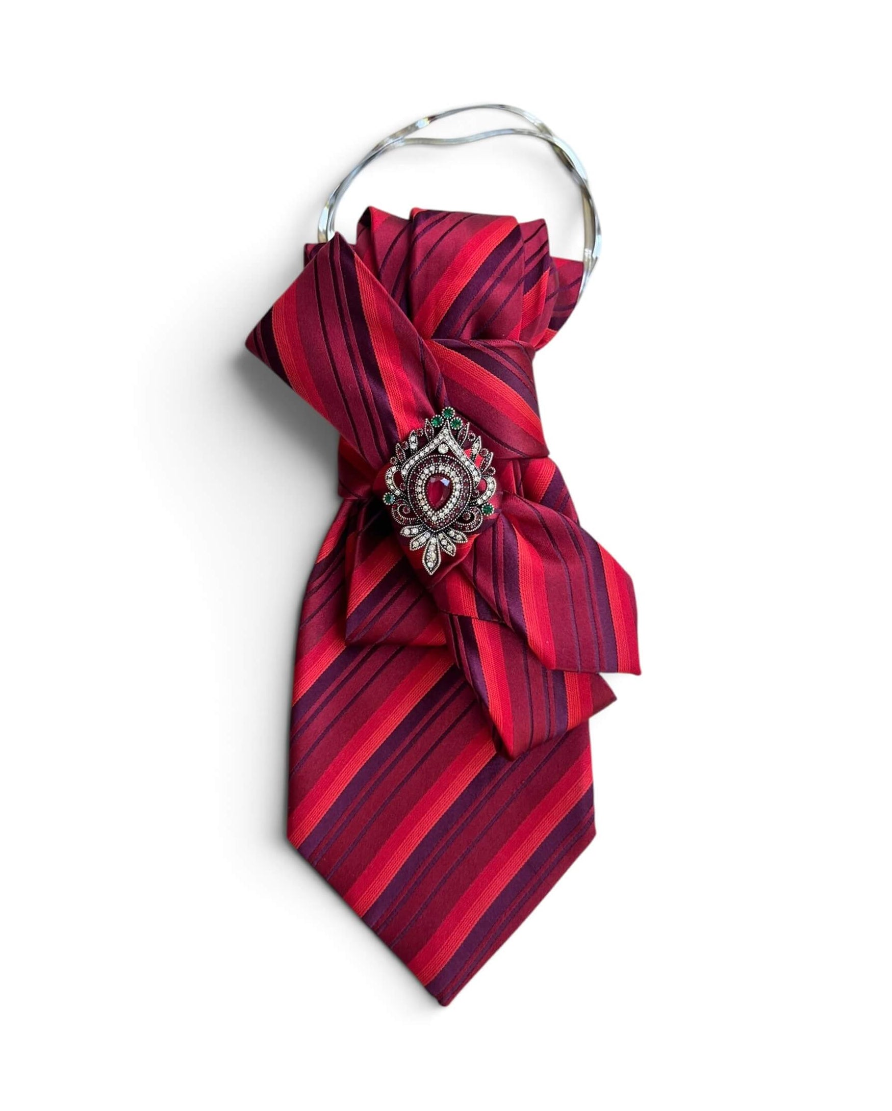 Statement-Krawatte aus Vintage-Seide in Rot und Bordeaux mit diagonalen Streifen sowie Schmuckbrosche mit rotem Stein an silberfarbener Kette.