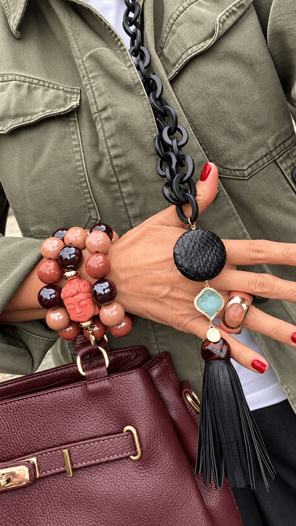 Casapari Buddha Armband-Set mit drei Armbändern aus schimmernden Resin-Perlen in Rosé, Terracotta und Bordeaux sowie Buddha aus Bambuskoralle, am Handgelenk getragen.