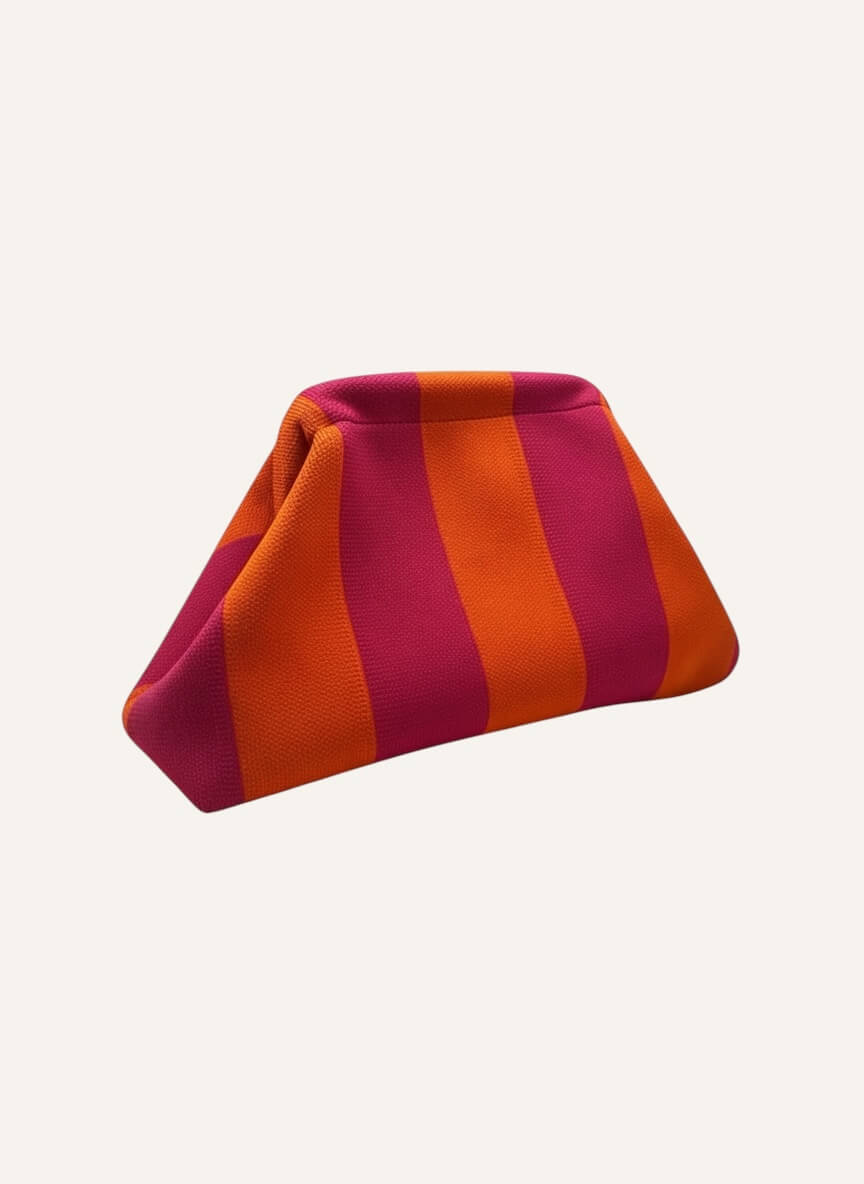 Gestreifte Clutch aus festem Canvas in Pink und Orange mit Klappverschluss vor neutralem, hellem Hintergrund.