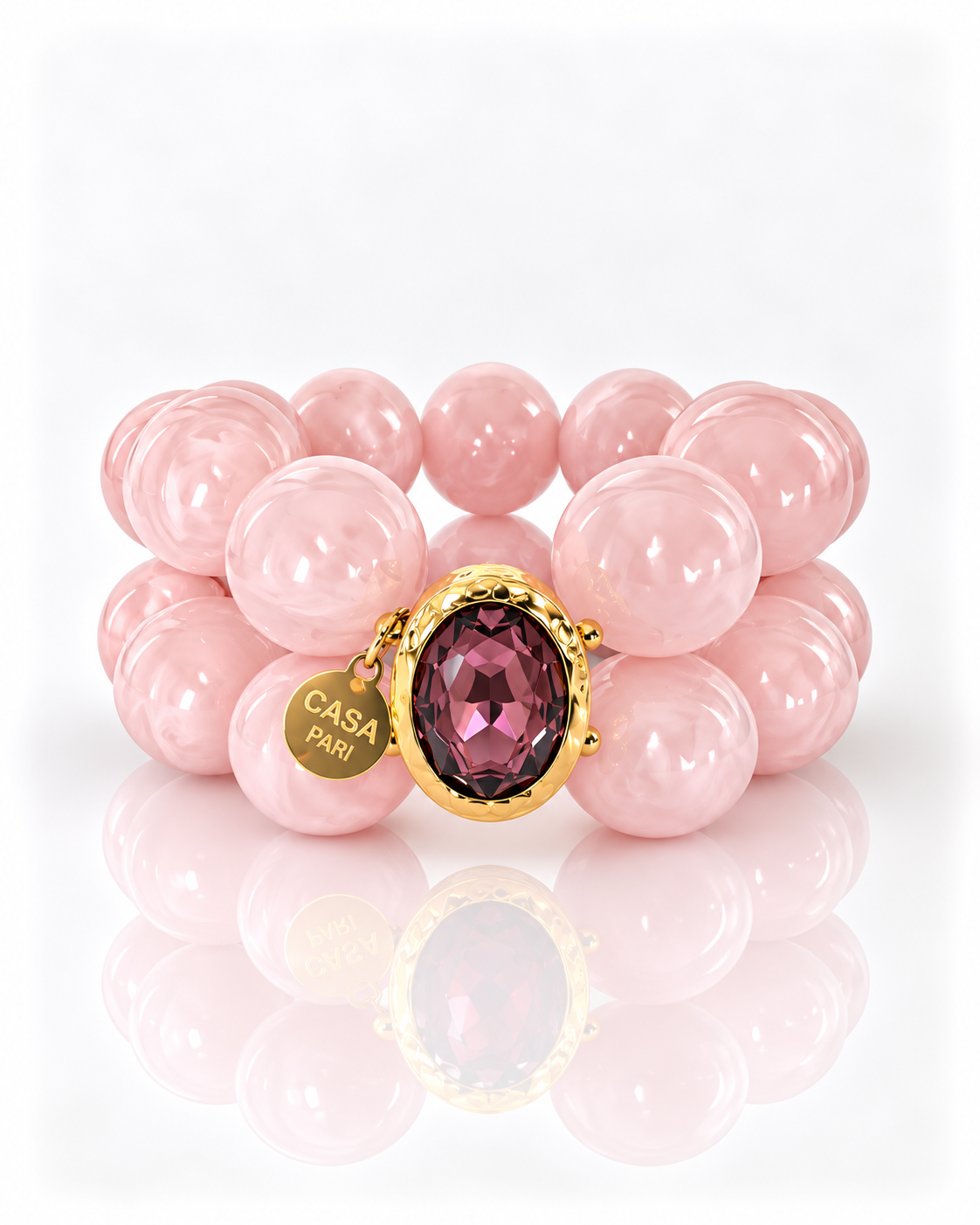 Crystal Blush – zweireihiges Perlenarmband mit facettiertem Kristall in goldfarbener Fassung und Casa Pari Anhänger auf weißem Hintergrund.