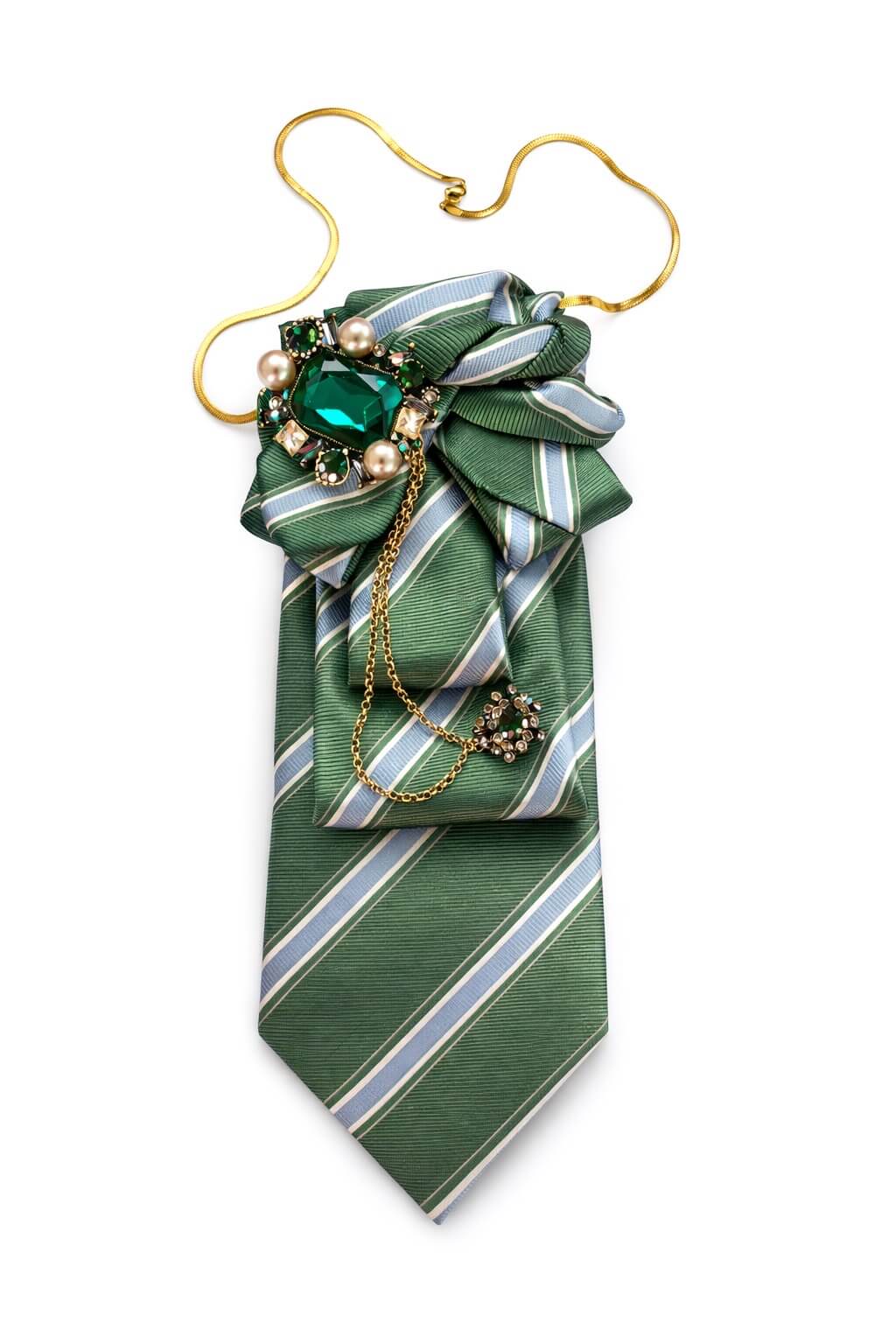 Grüne gestreifte Krawatte mit dekorativer Schleife, verziert mit einer großen grünen Schmuckbrosche, Perlen und einer goldfarbenen Kette, auf hellem Hintergrund.