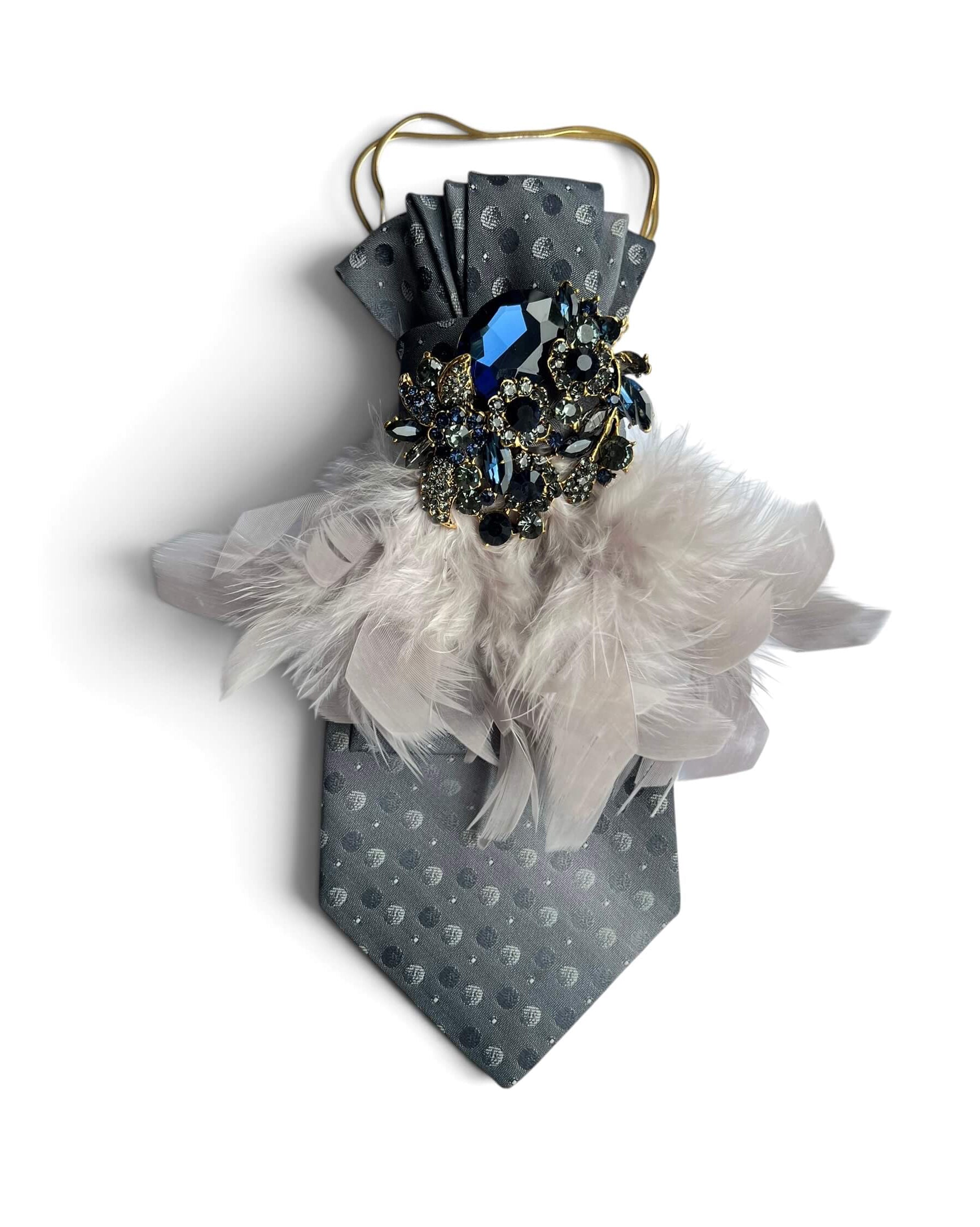 Graue Vintage-Seidenkrawatte von Casapari mit cremefarbenen Federn, dunkelblauer Schmuckbrosche und goldfarbener Kette.