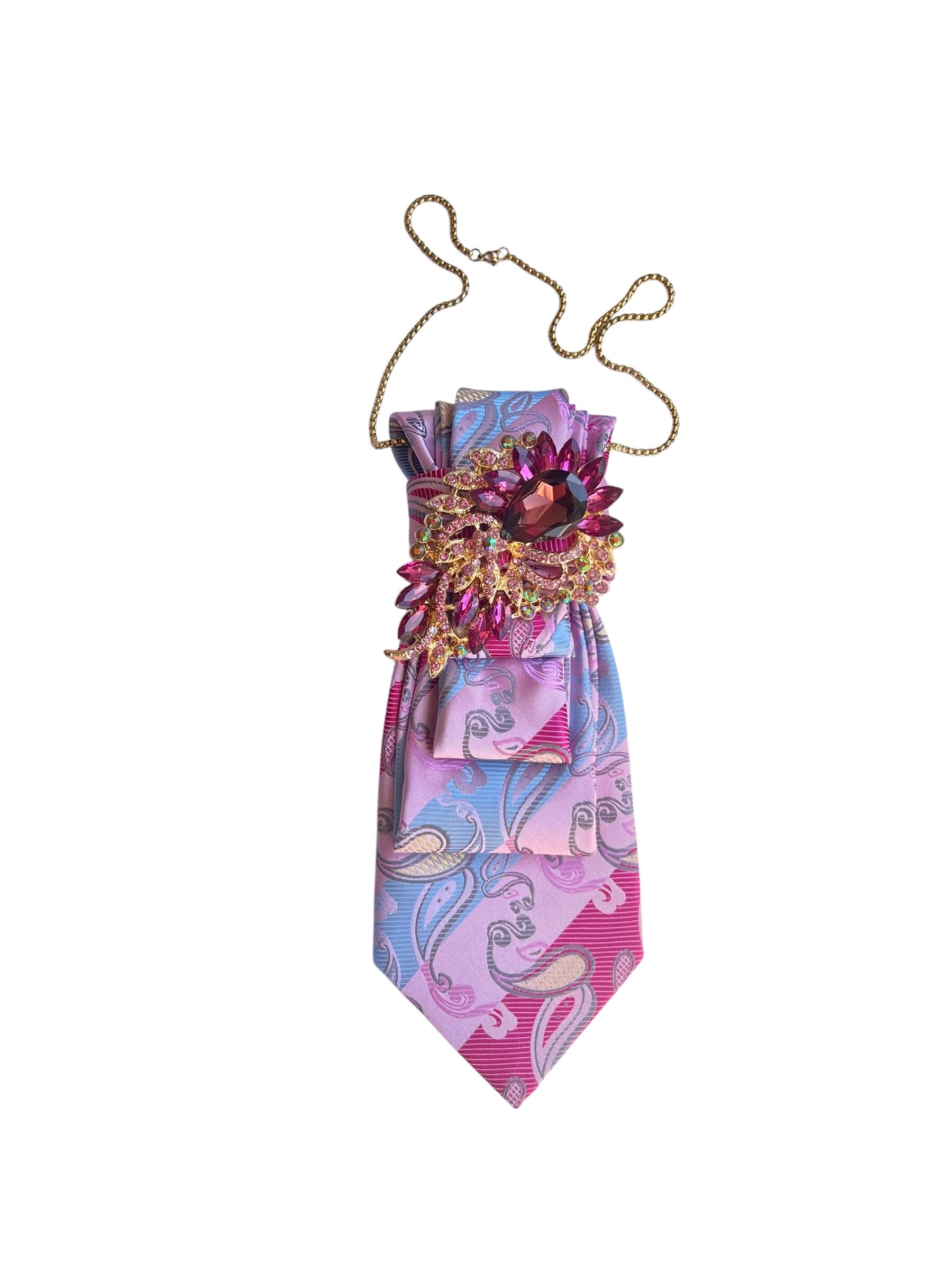 Pinkfarbene Paisley Rabatte mit dekorativer Schmuckbrosche auf weißem Hintergrund fotografiert