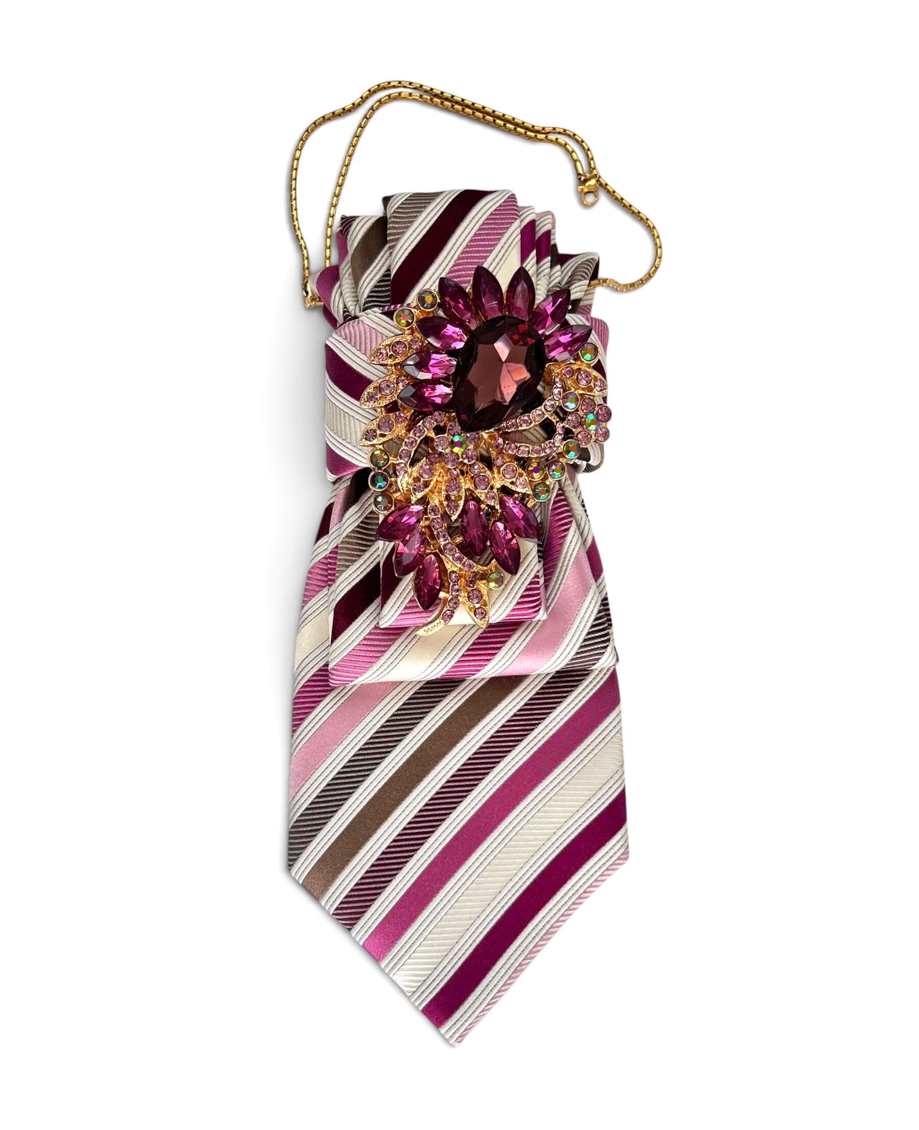 Gestreifte Krawattenkette in Pink, Bordeaux, Creme und Braun mit großer pinkfarbener Schmuckbrosche und goldfarbener Kette.