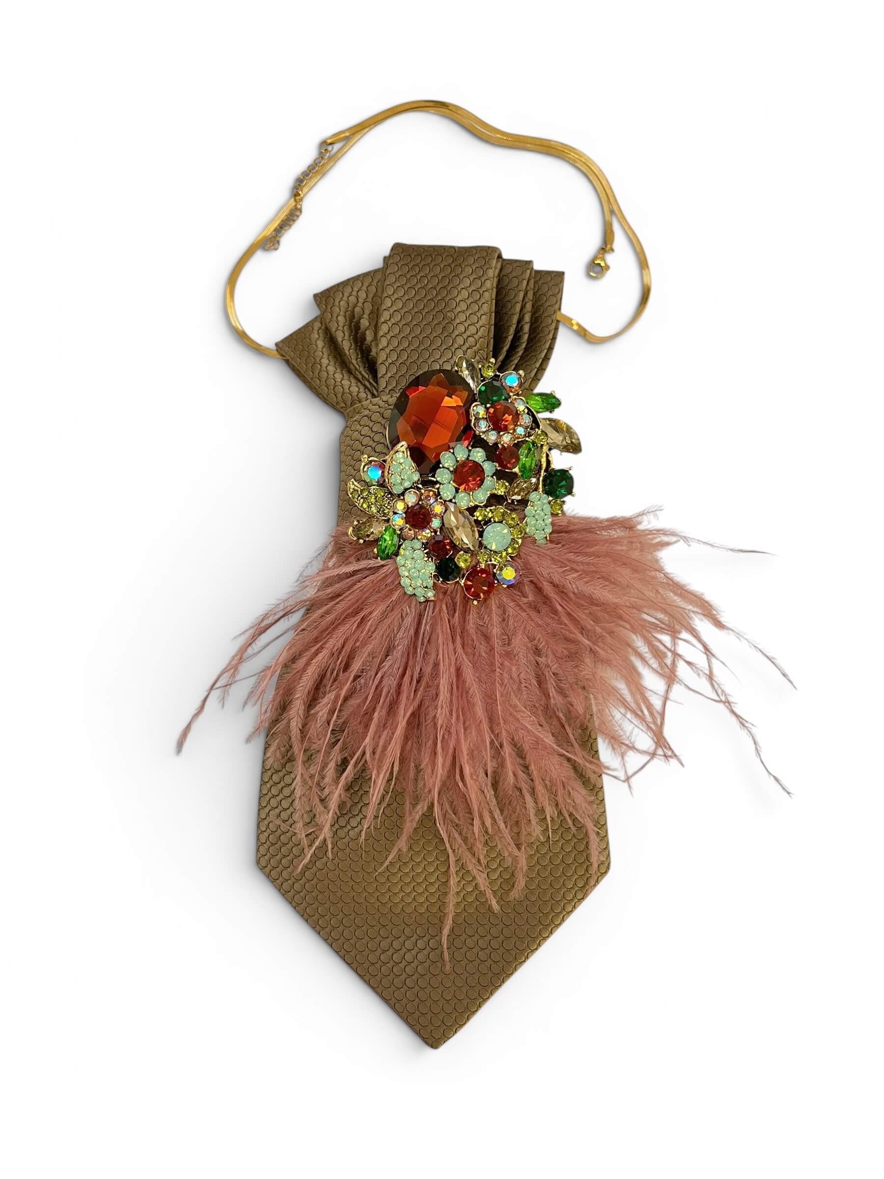 Vintage-Bindekrawatte in warmem Taupe-Bronzeton mit strukturierter Oberfläche, dekoriert mit einer auffälligen Schmuckbrosche mit mehrfarbigen Steinen und roséfarbenen Federn.