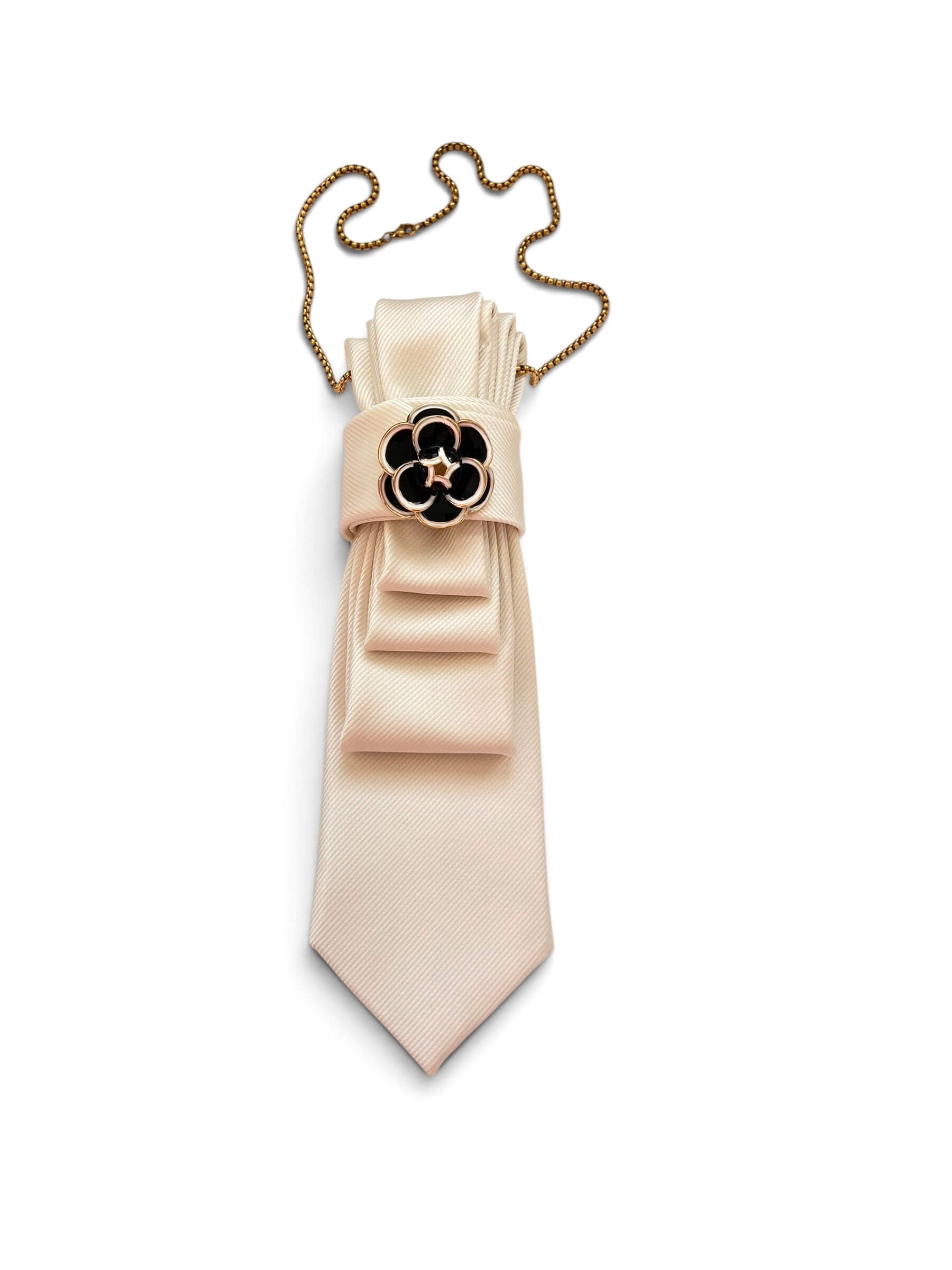 Cremefarbene Krawatte mit goldfarbener Kette und schwarzer, floraler Brosche mit goldenen Details.