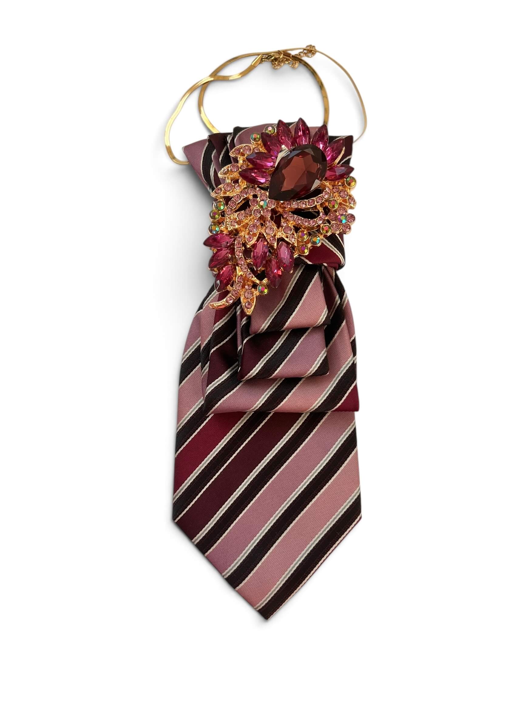 Vintage-Krawatte in Rosé, Bordeaux und Dunkelbraun mit Streifenmuster, dekorativ gebunden mit großer Brosche in Goldoptik mit pinkfarbenen Schmucksteinen.