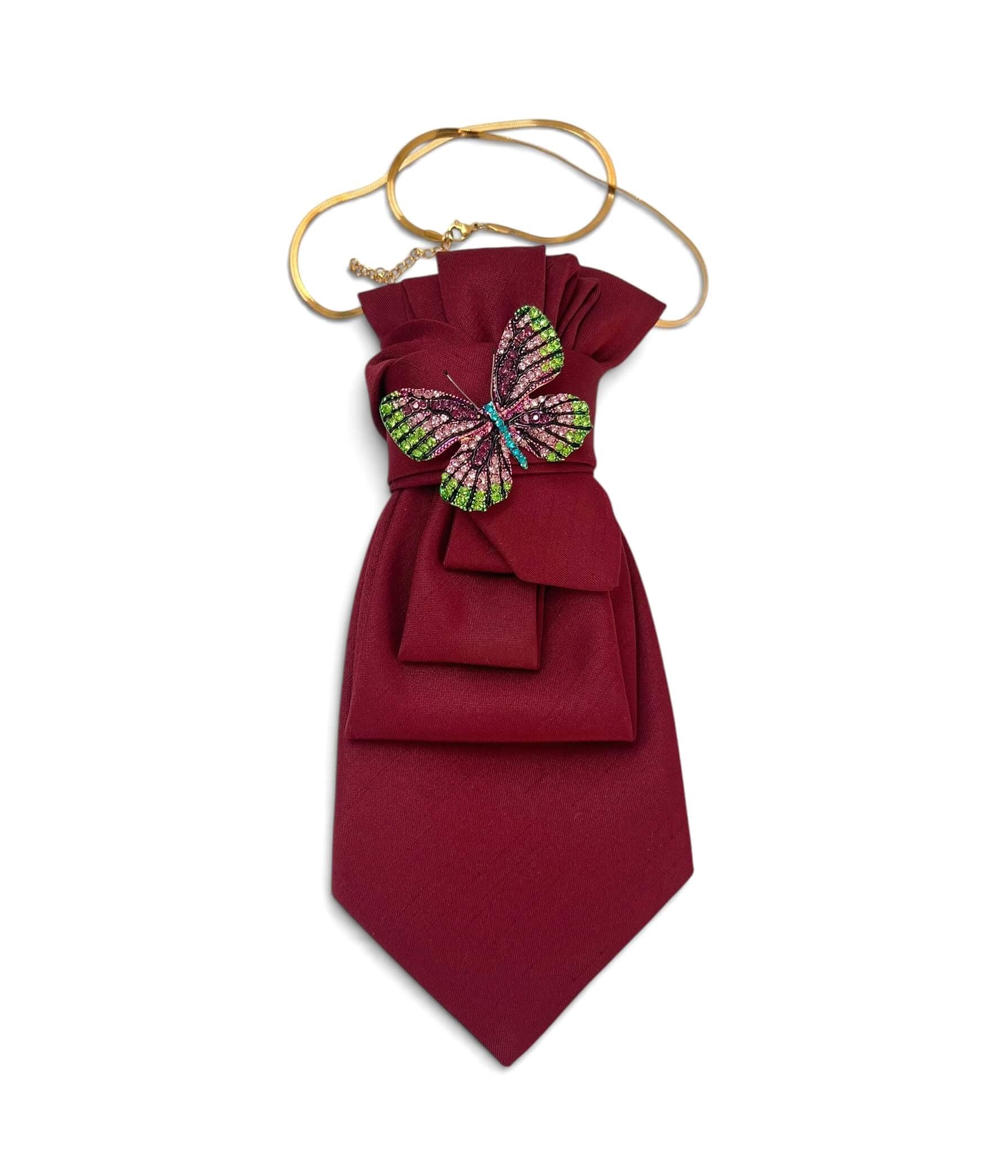 Vintage-Krawatte in tiefem Bordeauxrot, verziert mit dekorativer Schmetterlingsbrosche in Pink-, Grün- und Blautönen mit Schmucksteinen.