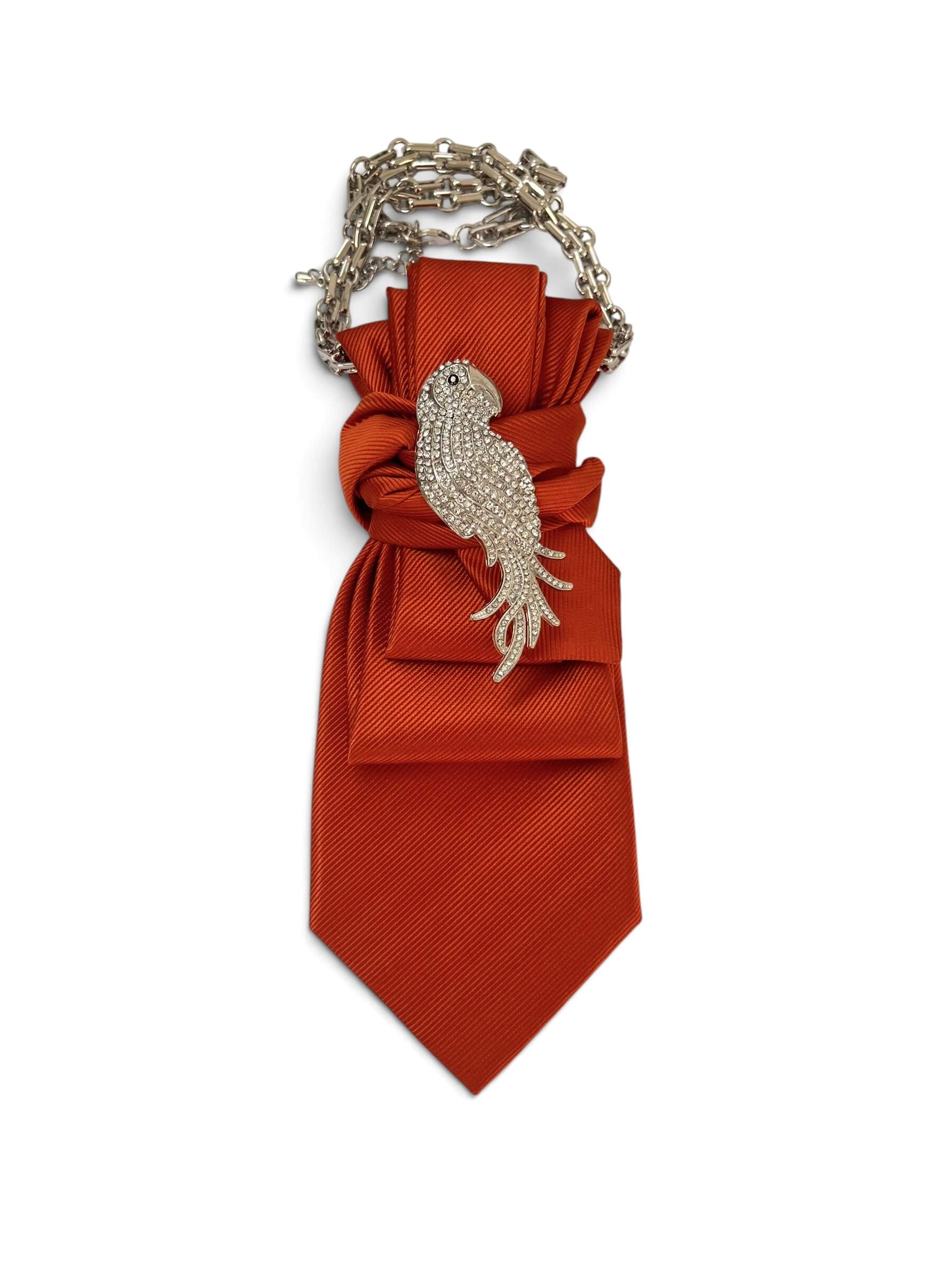Vintage-Krawatte in kräftigem Orange mit feiner Struktur, verziert mit silberfarbener Vogelbrosche mit Strassbesatz und dekorativer Kette.