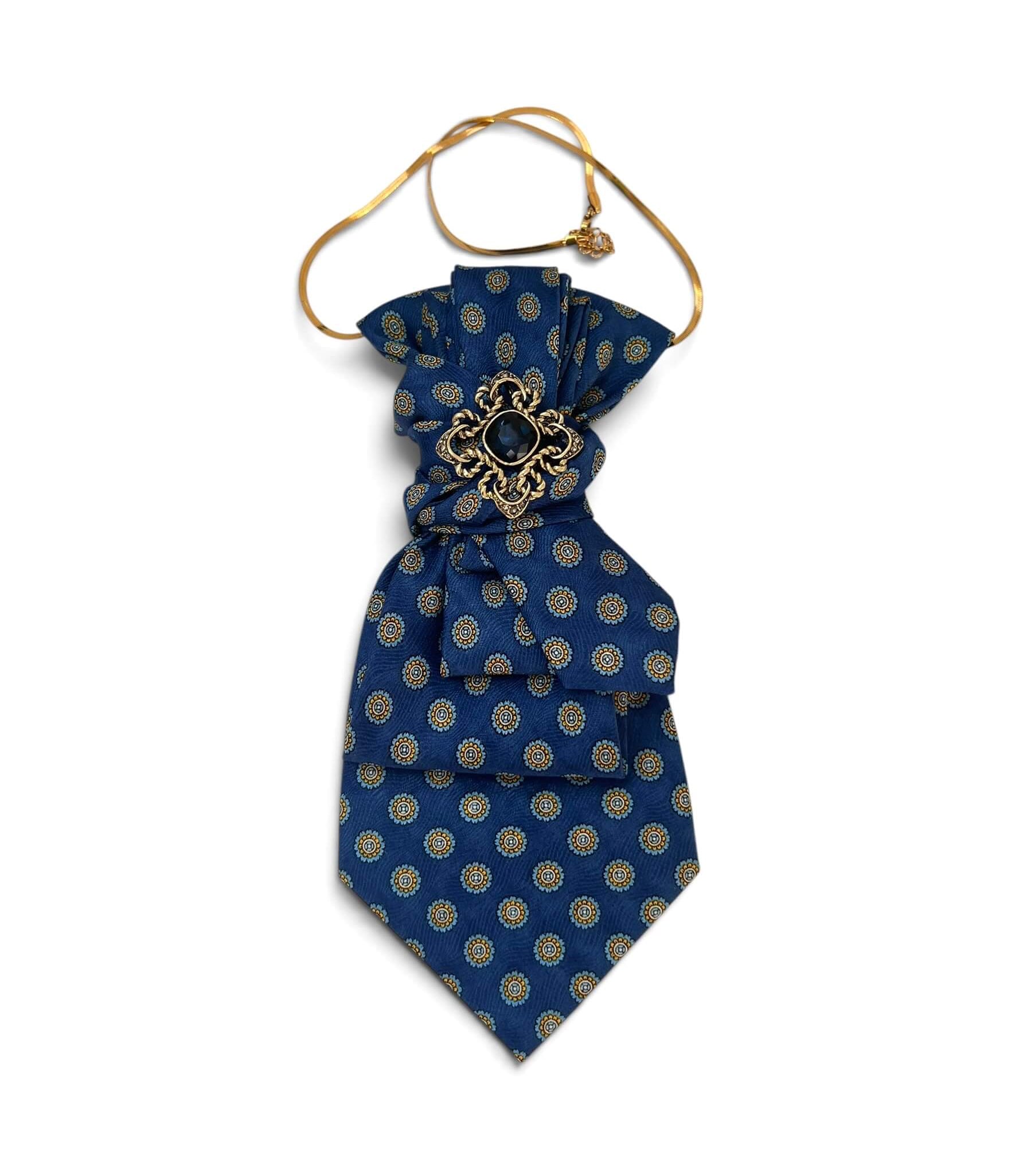 Vintage-Krawatte in kräftigem Blau mit feinem ornamentalen Muster, verziert mit goldfarbener Schmuckbrosche mit dunklem blauen Schmuckstein.