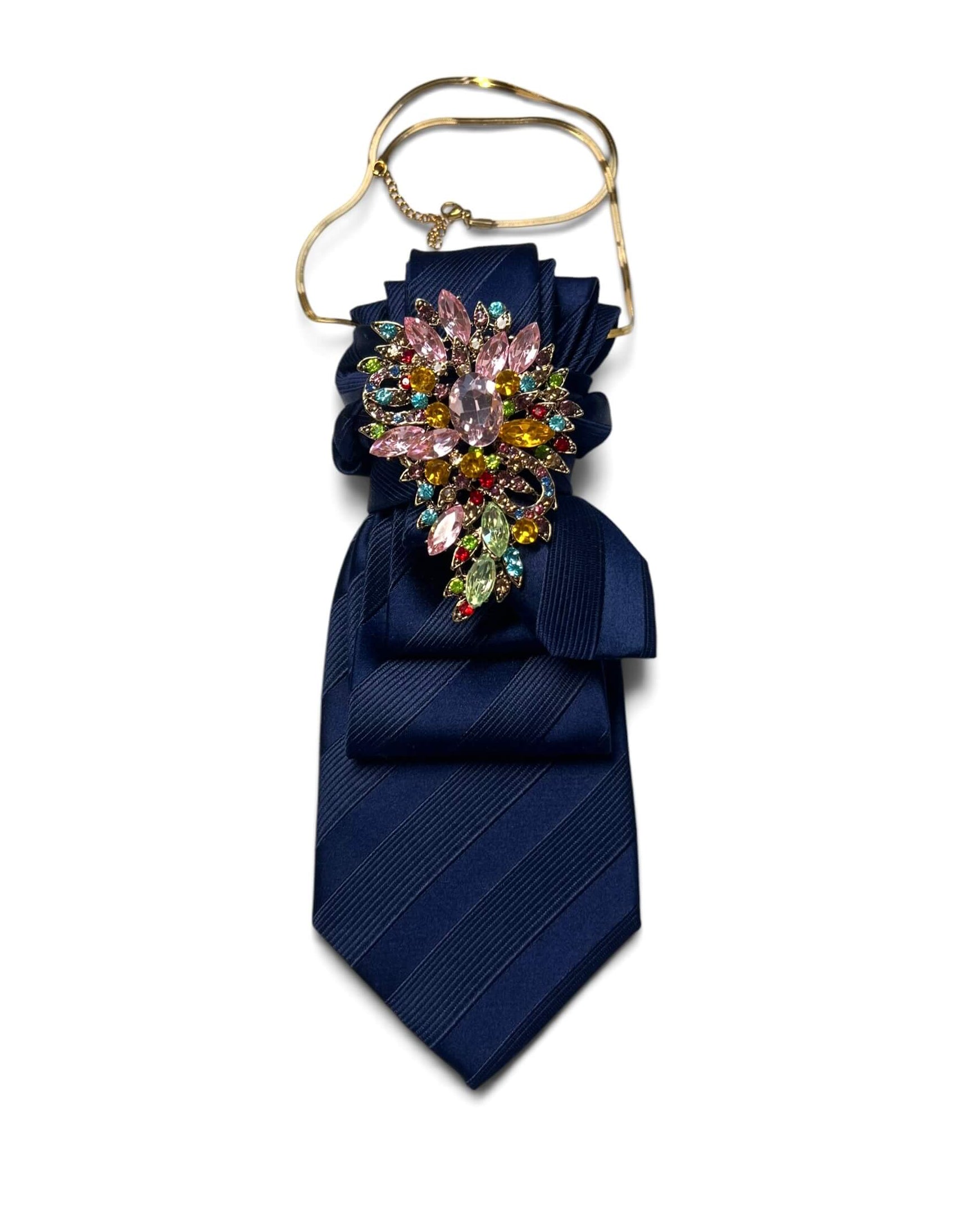 Dunkelblaue Vintage-Krawatte mit diagonalem Strukturmuster, dekorativ drapiert mit farbiger Schmuckbrosche und goldfarbener Kette.