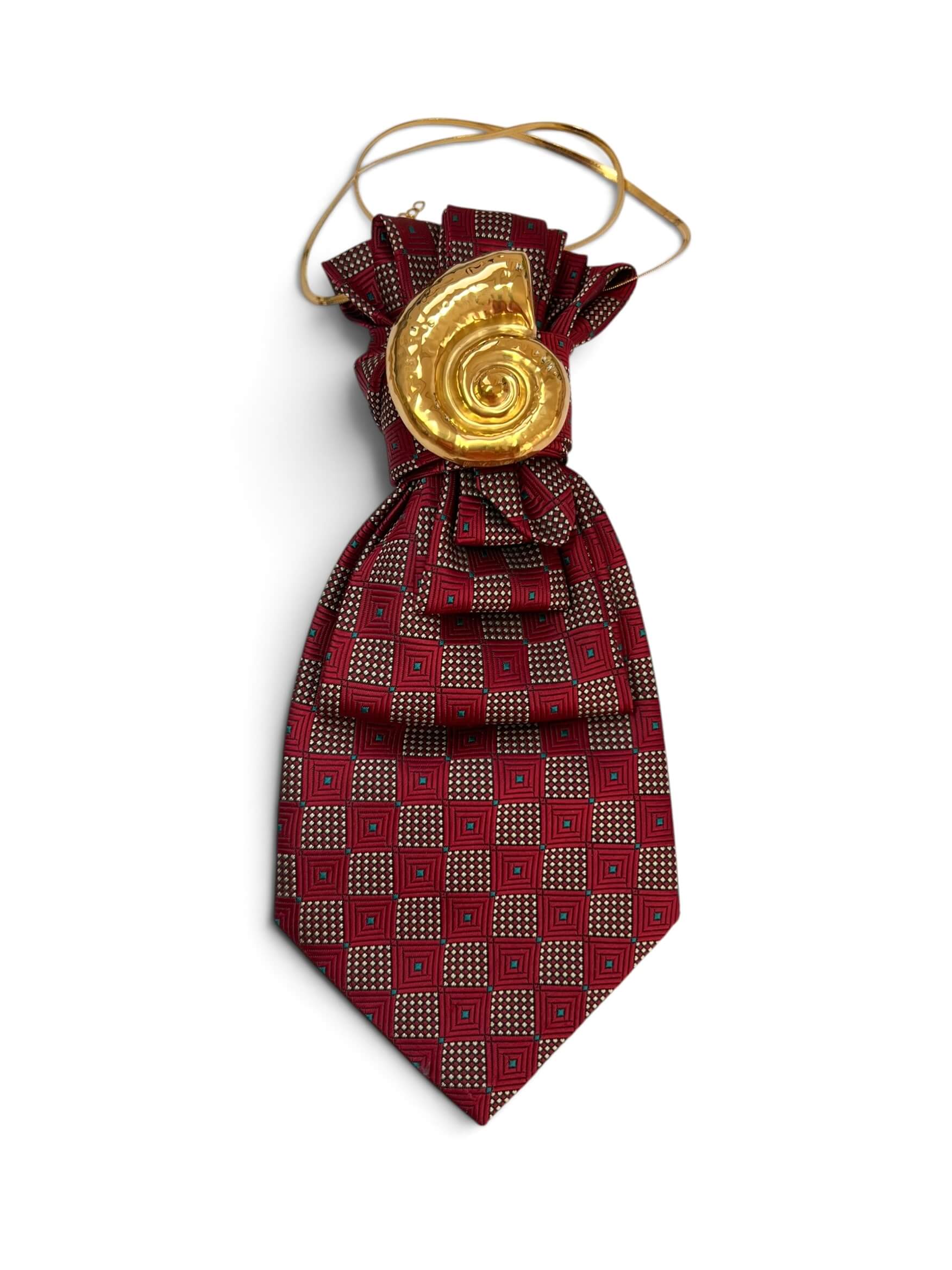 Vintage-Krawatte in Bordeauxrot mit geometrischem Muster, dekorativ gebunden mit großer goldfarbener spiralförmiger Schmuckapplikation.