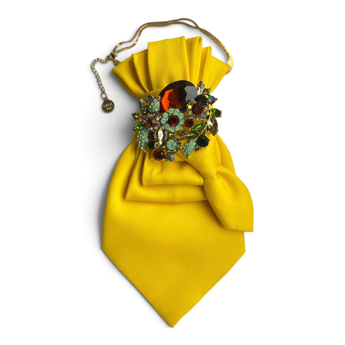 Gelbe Vintage-Krawatte von Casapari mit großer mehrfarbiger Strassbrosche in Rot, Grün, Türkis und Gold auf weißem Hintergrund.