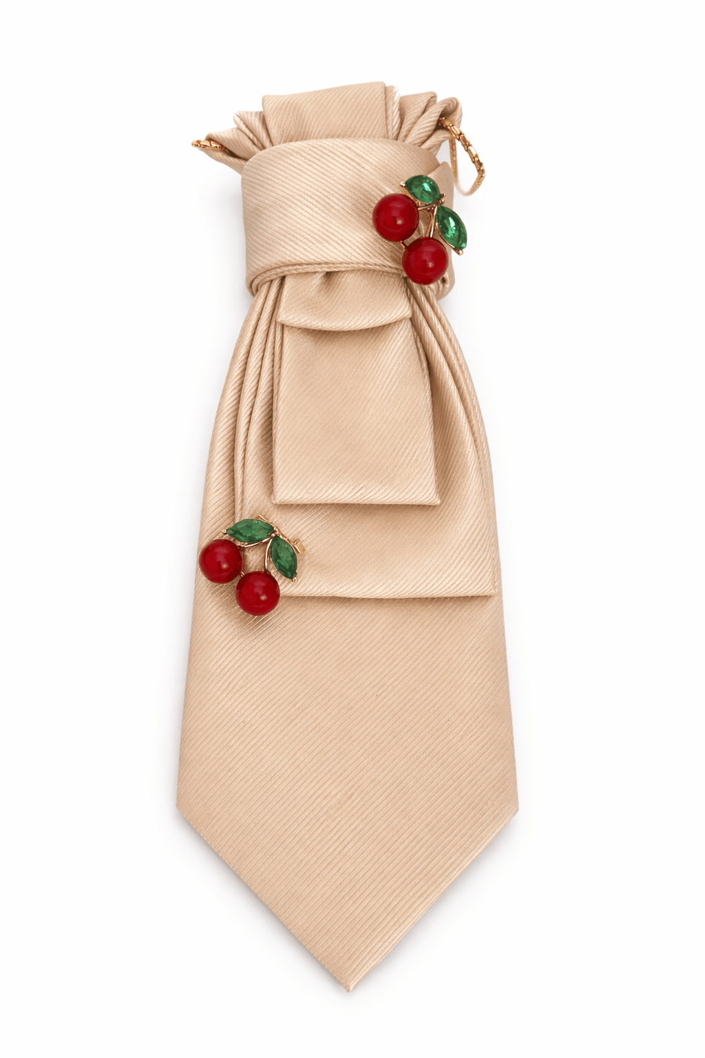 Champagnerfarbene Seidenkrawatte mit zwei roten Kirschbroschen und grünen Blättern, dekorativ gelegt auf hellem Hintergrund