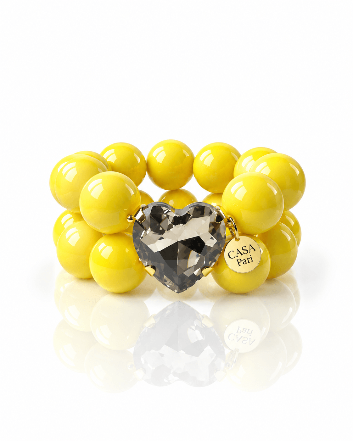 Crystal Heart Armband Lemon Smoke mit großen gelben Resinperlen, facettiertem Herzstein in rauchigem Grau und goldfarbenen Details von Casapari.