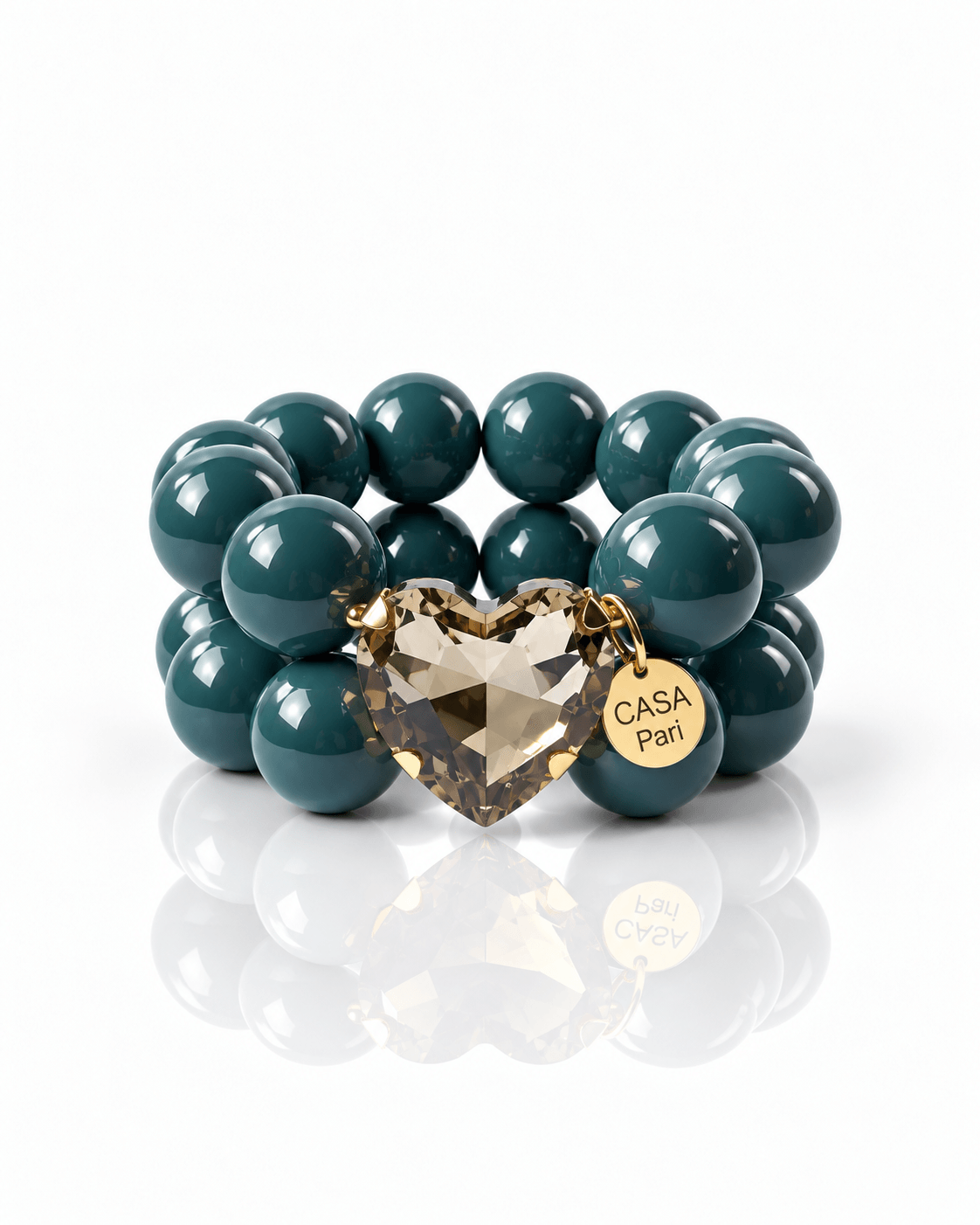 Crystal Heart Armband Petrol Cognac mit petrolfarbenen Resinperlen, rauchigem Cognac-Herz und goldenem Casa Pari Anhänger.