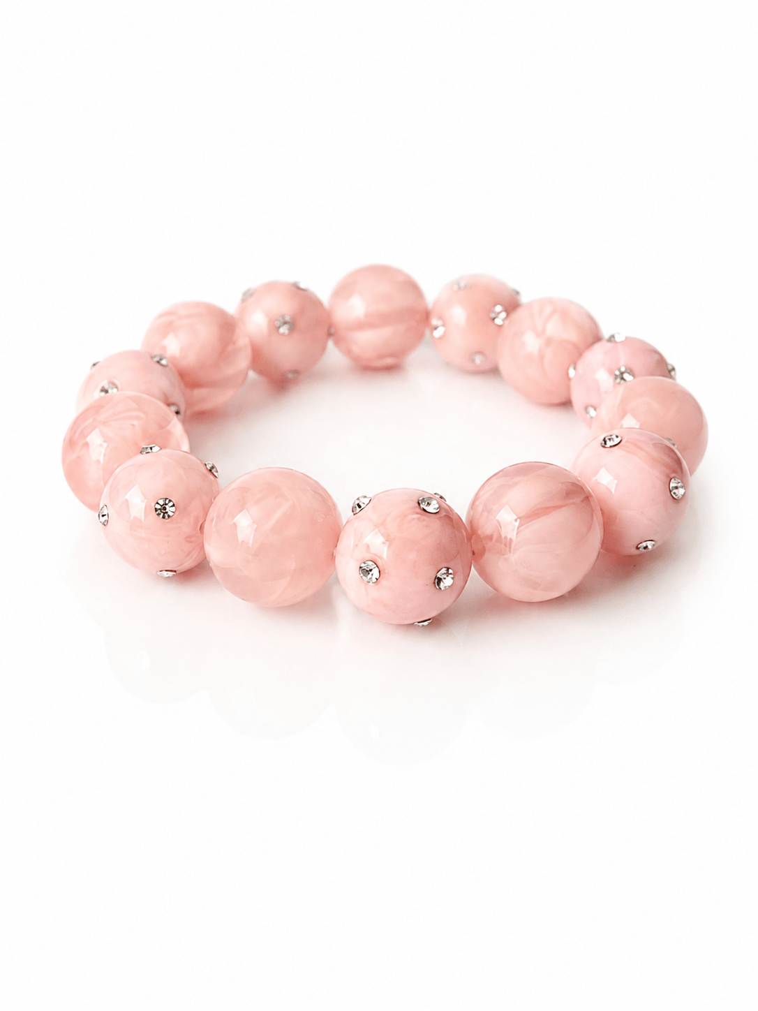Rosa Armband mit marmorierten Kunstharzperlen und kleinen Strasssteinen auf weißem Hintergrund fotografiert.