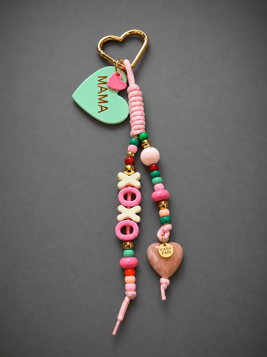 MAMA Bag Charm von CASAPARI mit mintfarbenem Herz, XOXO Buchstaben in Pink und Creme, bunten Perlen, Herzanhänger und goldfarbenem Herz-Karabiner.