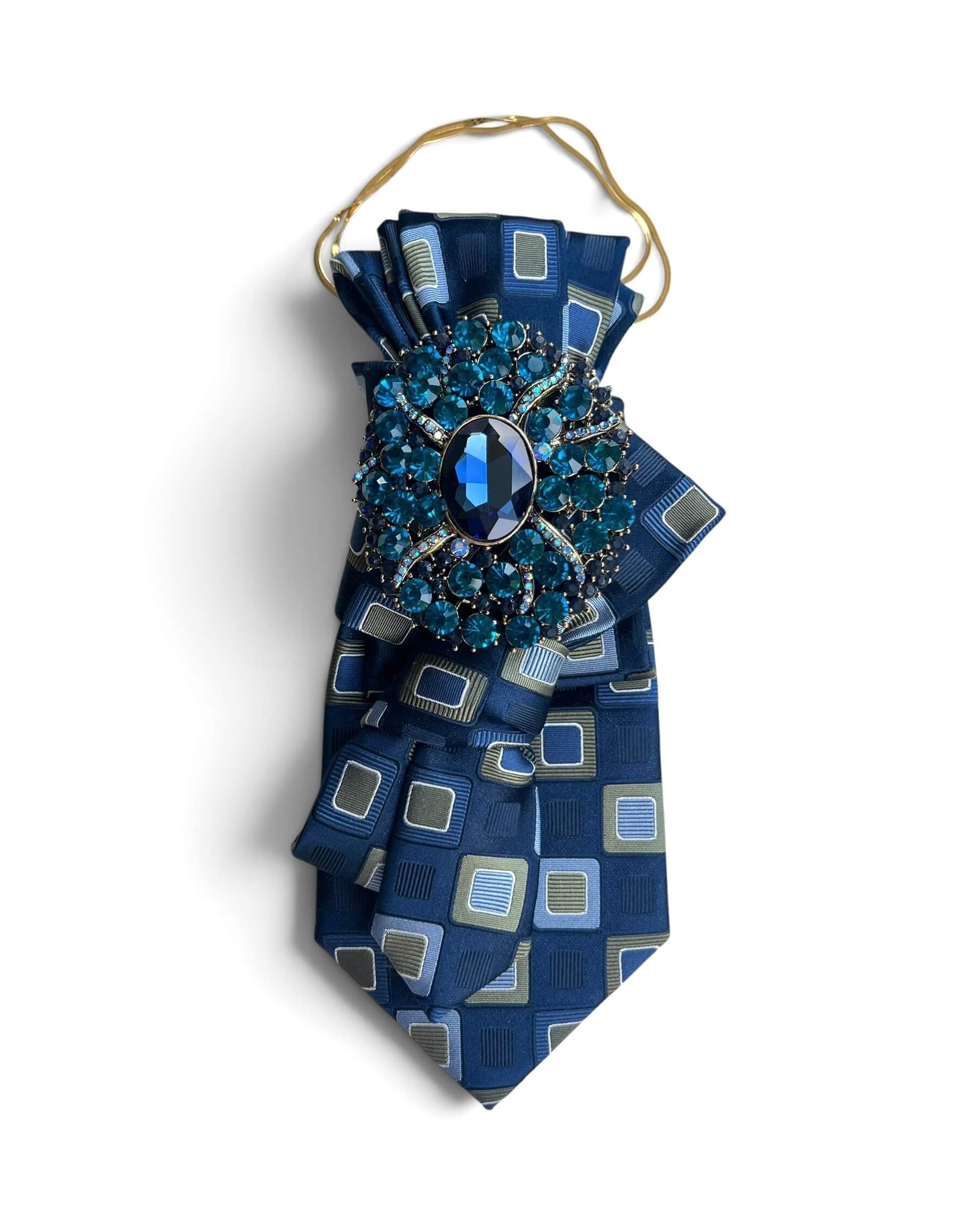 Blaue Statement-Krawatte aus Vintage-Seide mit grafischem Muster, goldfarbener Kette und großer blauer Schmuckbrosche.