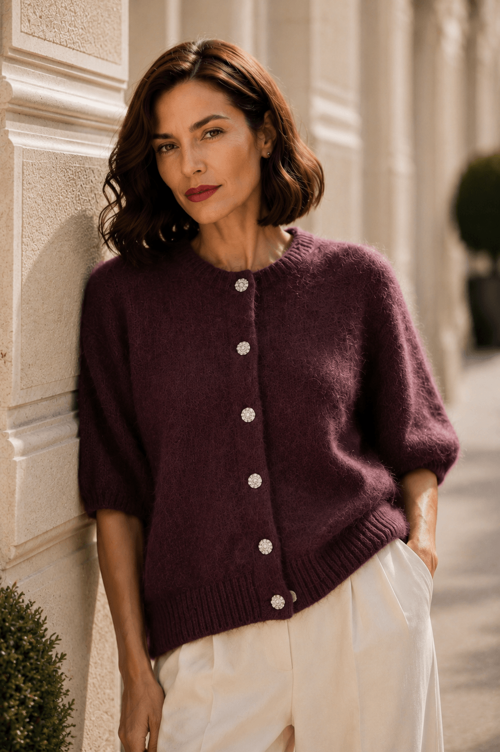 Braunes Milano Kid Mohair Cardigan mit Schmuckknöpfen, Halbarm und flauschiger Struktur, kombiniert mit einer hellen Marlenehose.