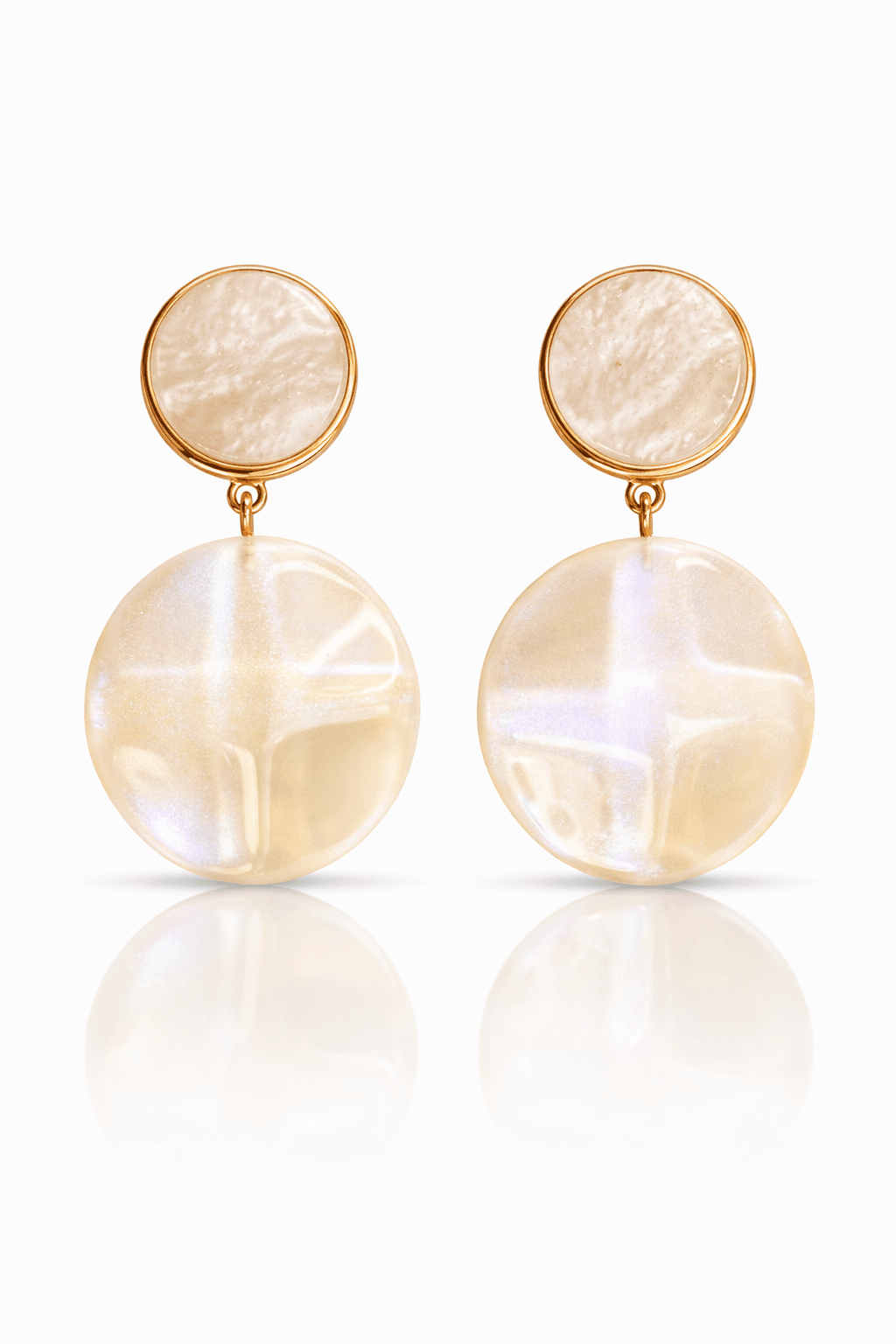 Hängende Ohrringe mit rundem, creme Oberteil und großem, glänzendem Anhänger in creme, goldfarbene Fassung, auf hellem Hintergrund.