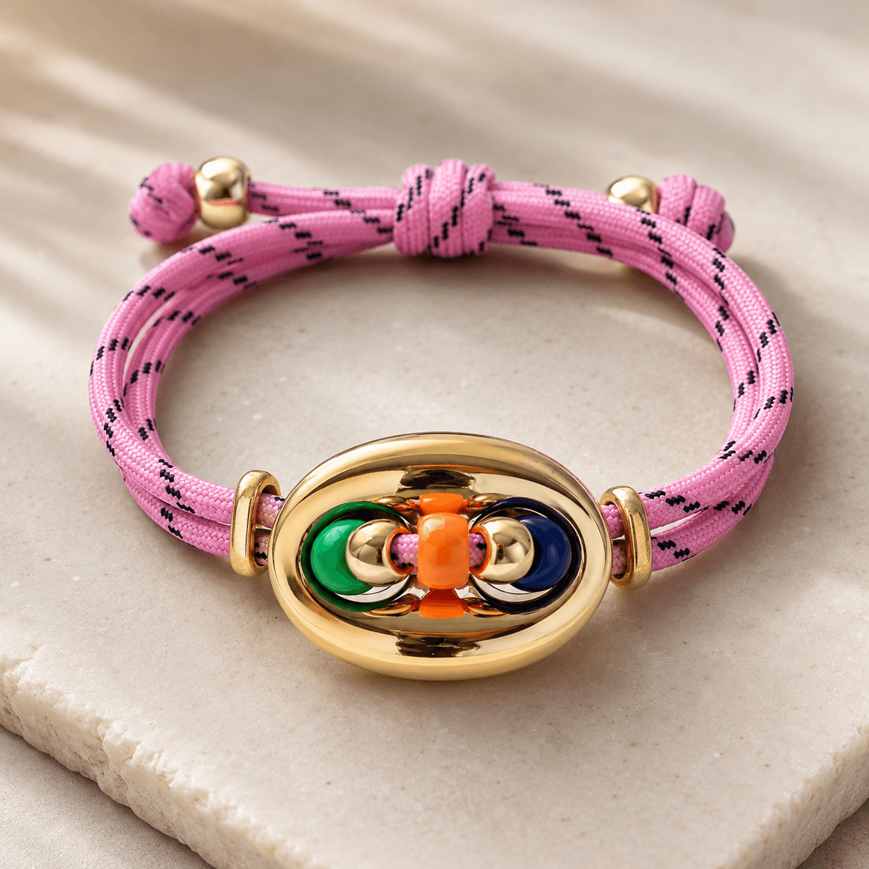 Das Armband mit dem goldenen Element liegt auf einem Steinplatte