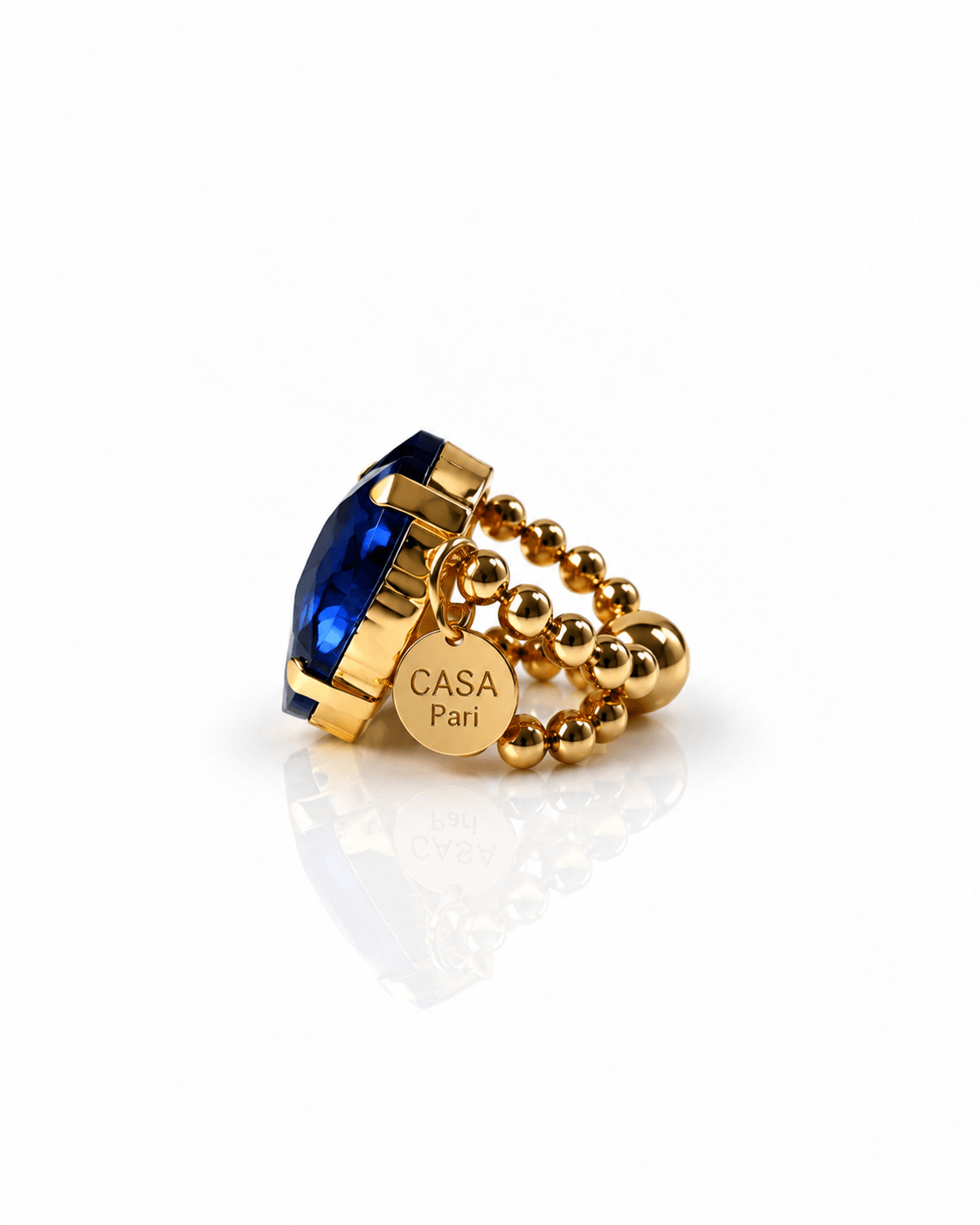 Goldfarbener Crystal Heart Ring mit großem facettiertem Herzstein in intensivem Royalblau und elastischem Perlenring