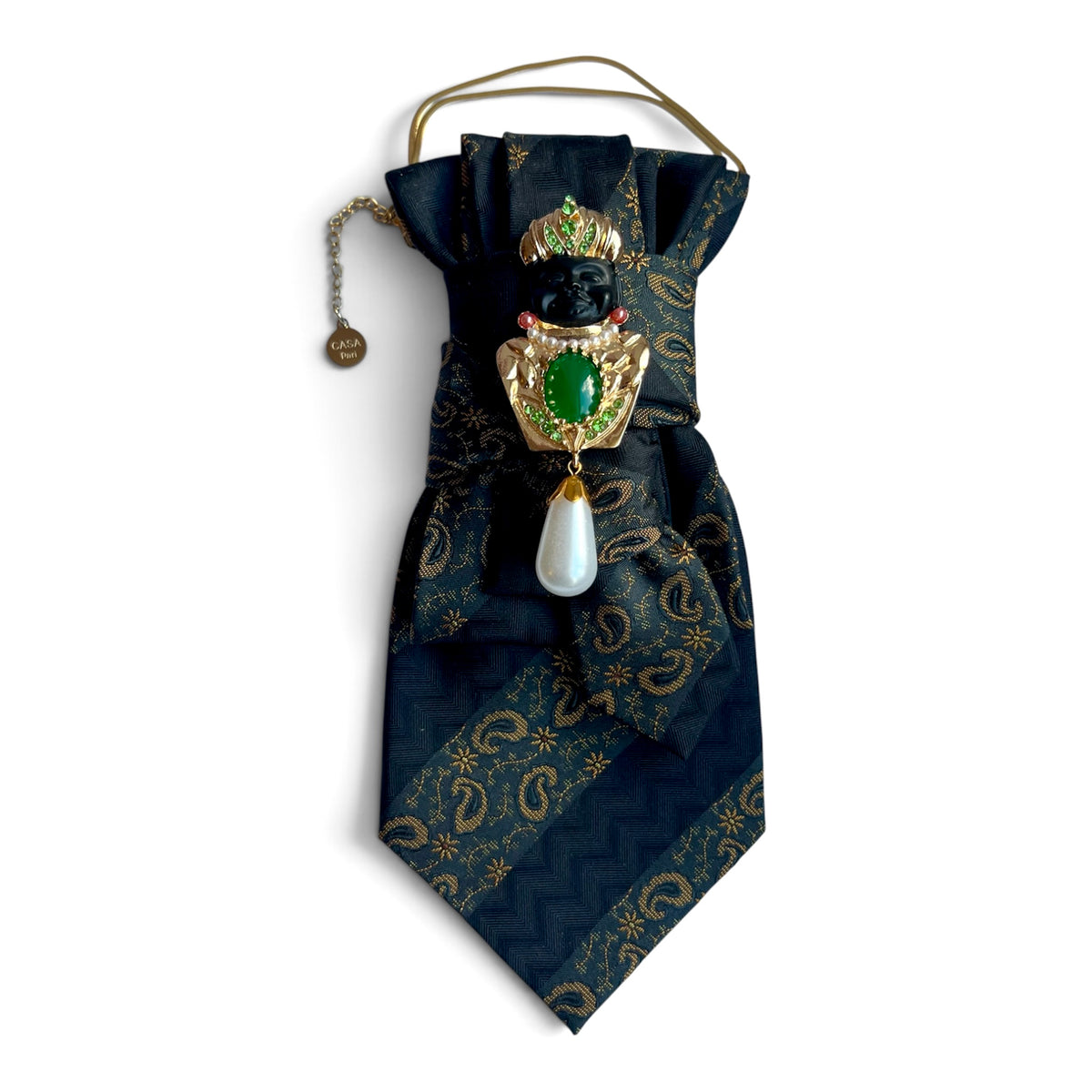 Dunkelblaue Seidenkrawatte mit goldenem Paisleymuster, grüner Schmuckbrosche, Perlenanhänger und goldfarbener Kette