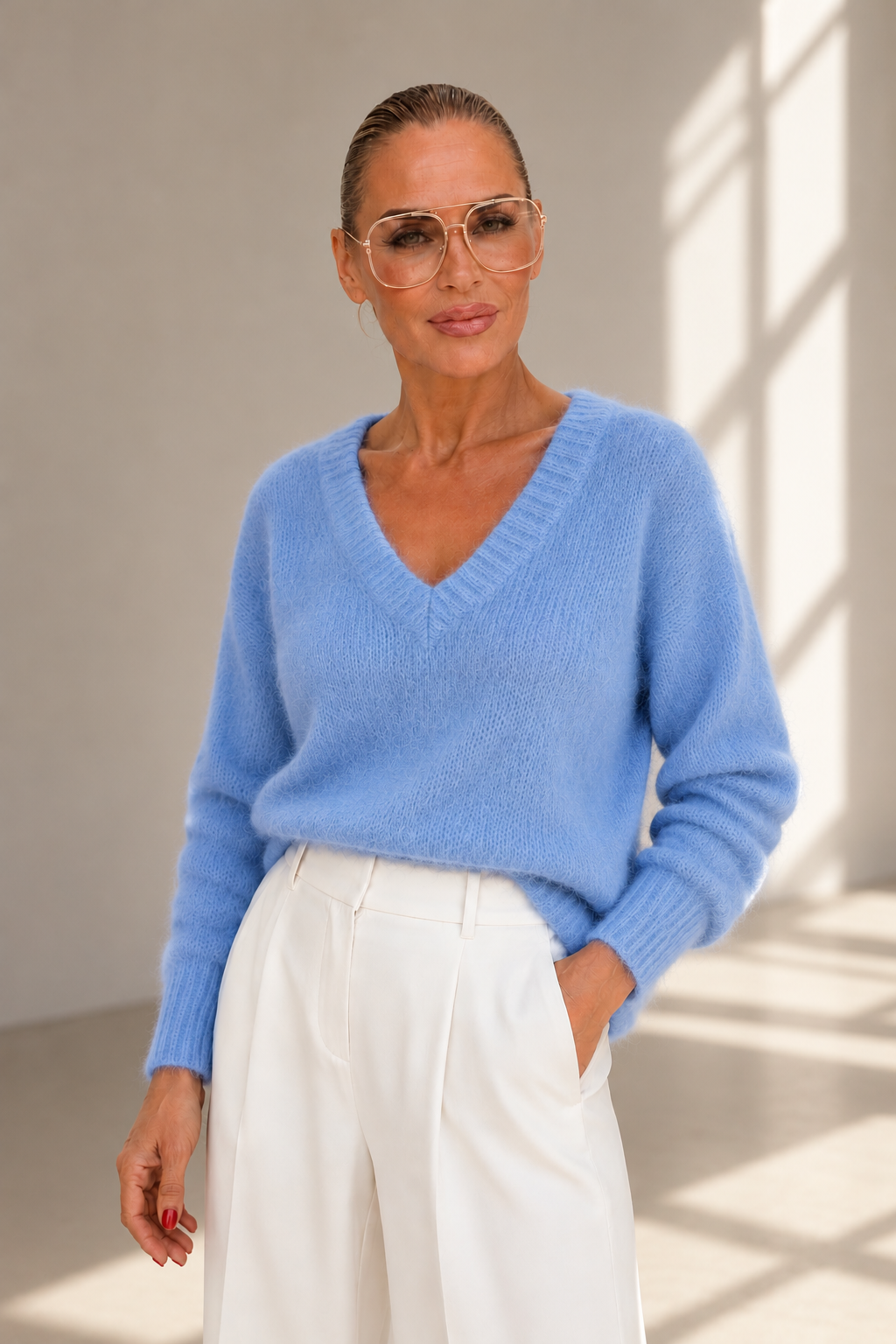 KI-generiertes Editorial: Sky Blue Kid Mohair Pullover mit V-Ausschnitt, Model in weißer Marlenehose vor schlichtem Hintergrund