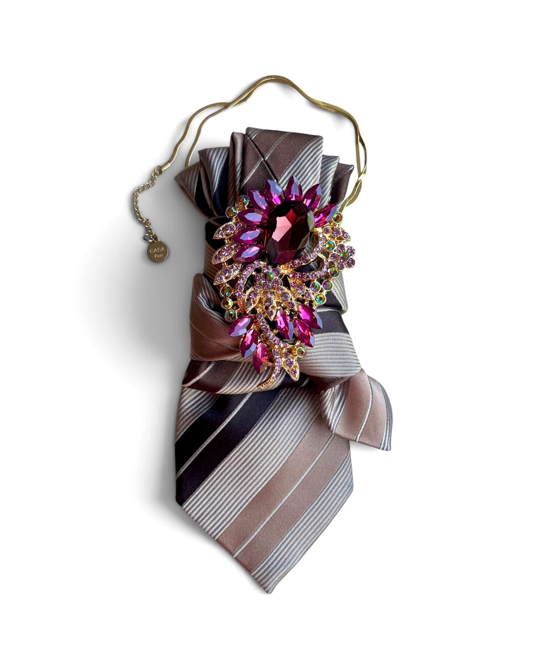 Statement-Krawatte aus Vintage-Seide in Taupe, Grau und Braun mit pink-violetter Schmuckbrosche und goldfarbener Kette.