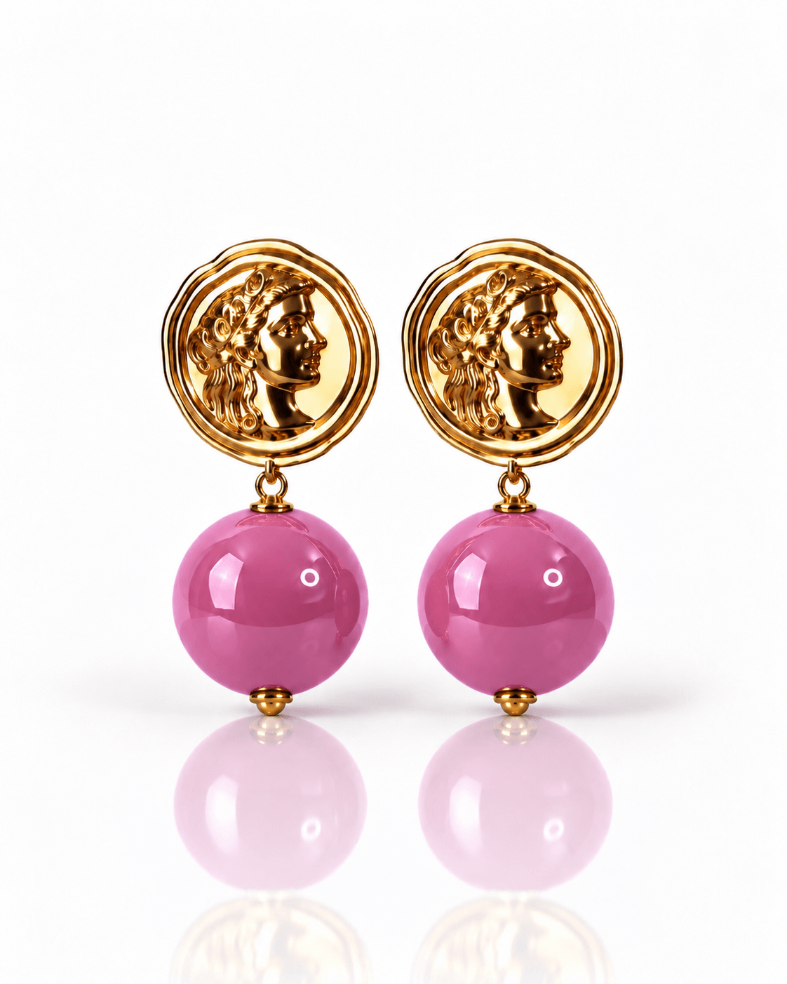 Goldfarbene Statement-Ohrringe mit rundem Medaillon und großer pinkfarbener Perle.