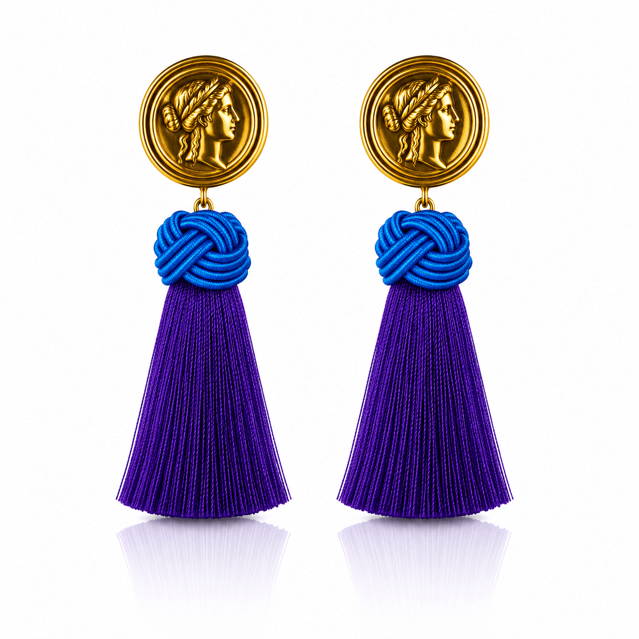 Goldfarbene Statement-Ohrringe mit Münzmotiv, leuchtend blauem Knoten und violetten Quasten.
