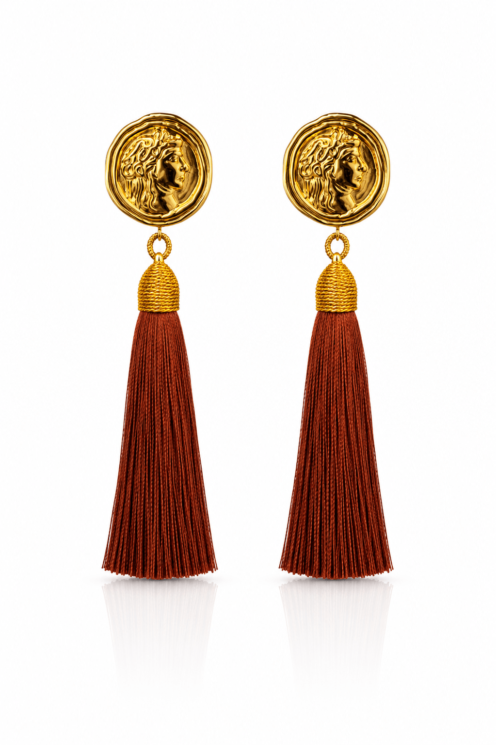 Goldfarbene Statement-Ohrringe mit römisch inspirierter Münze und langen Tasseln in warmem Terracotta.